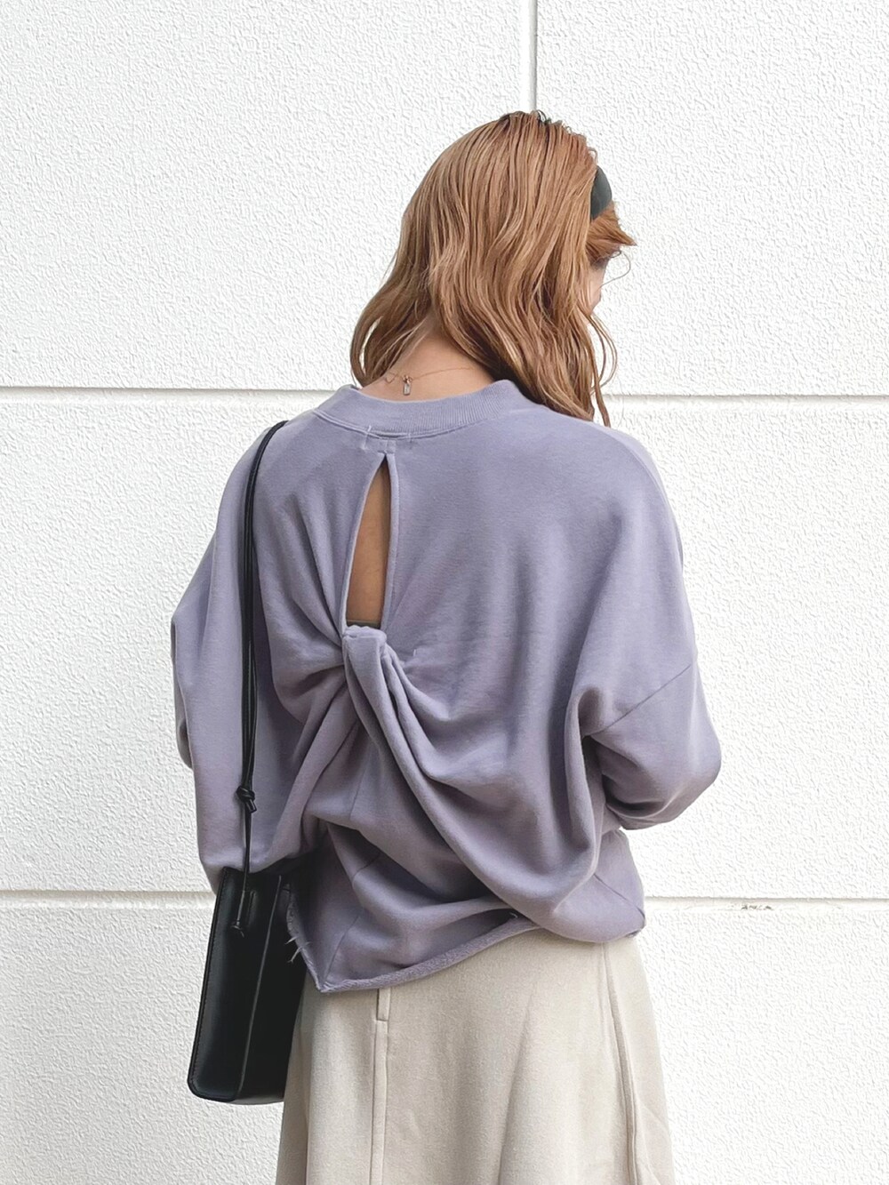 パープル系のスウェット、ブラック系のショルダーバッグ、ベージュ系のスカートを着用したレディースの秋コーディネートの3枚目の写真