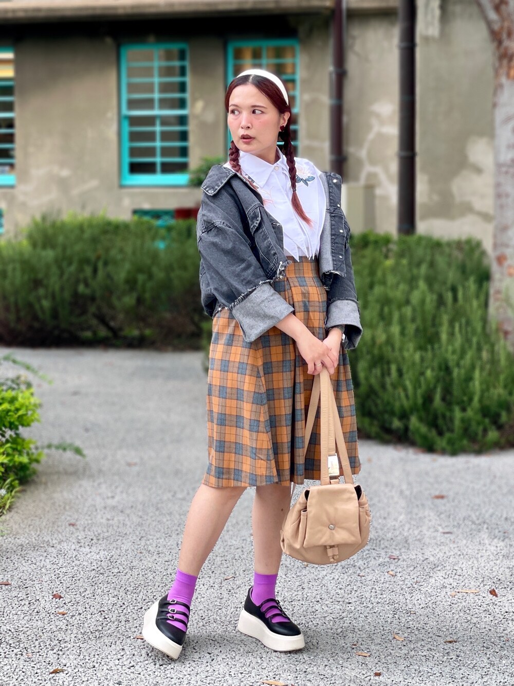 ベージュ系のバックパック/リュック、ブラック系のシューズ、オレンジ系のスカートを着用したレディースの秋コーディネートの2枚目の写真