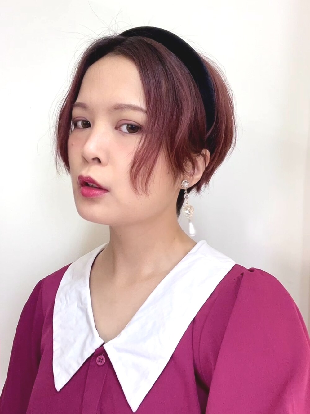 ブラック系のバッグ、レッド系のワンピースを着用したレディースの春コーディネートの2枚目の写真