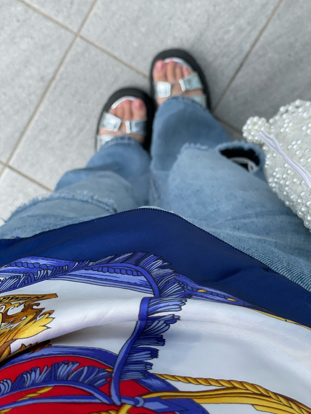 ブルー系のデニムパンツ、シルバー系のサンダルを着用したレディースの秋コーディネートの3枚目の写真