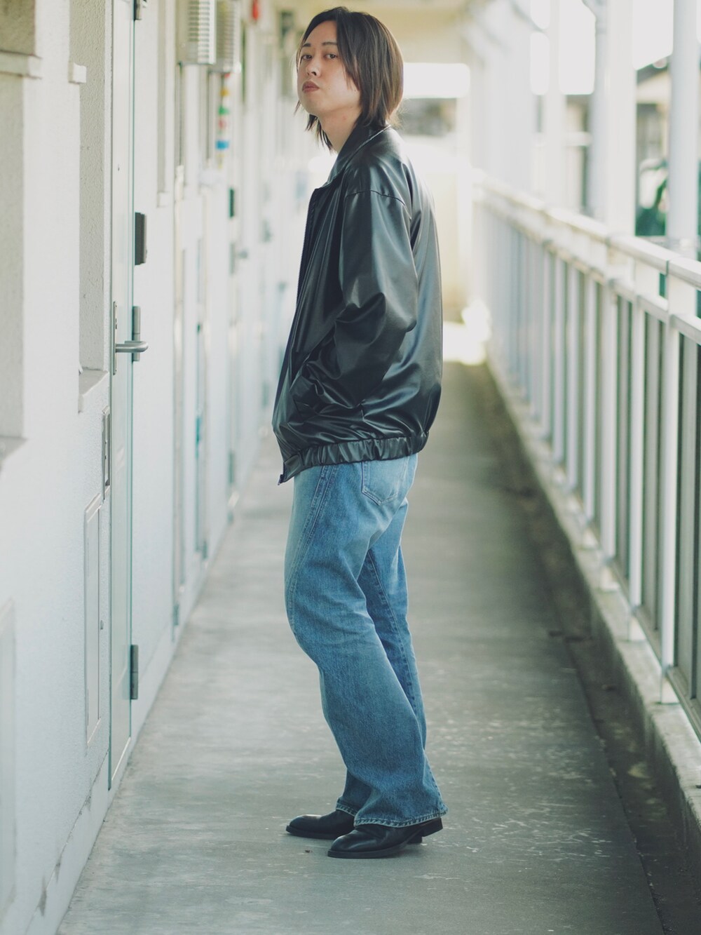 ブルー系のデニムパンツ、ブラック系のサンダル、ホワイト系のTシャツ/カットソーを着用したメンズの春コーディネートの2枚目の写真