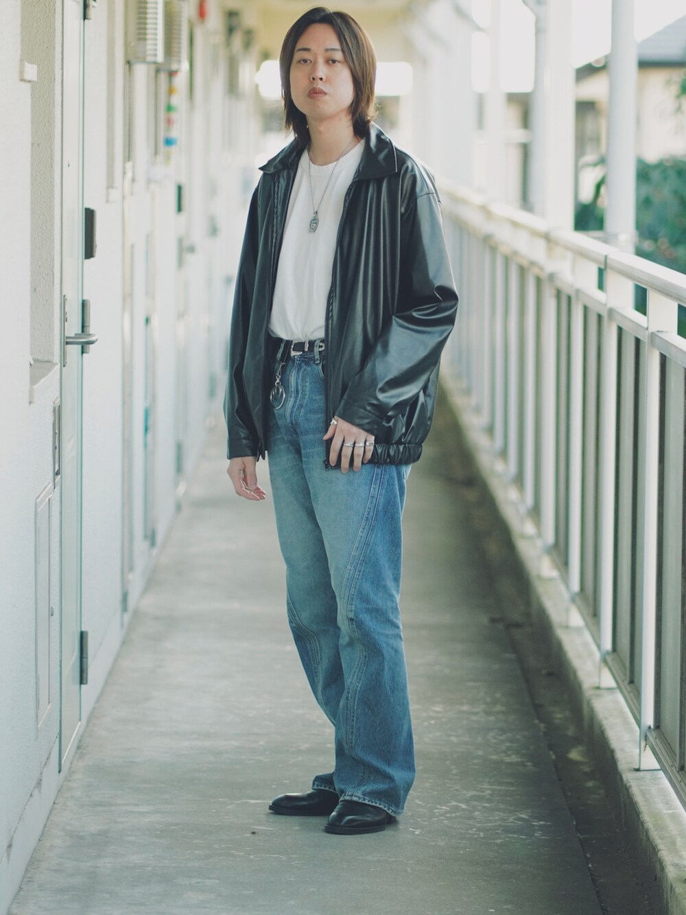 ブルー系のデニムパンツ、ブラック系のサンダル、ホワイト系のTシャツ/カットソーを着用したメンズの春コーディネートの4枚目の写真