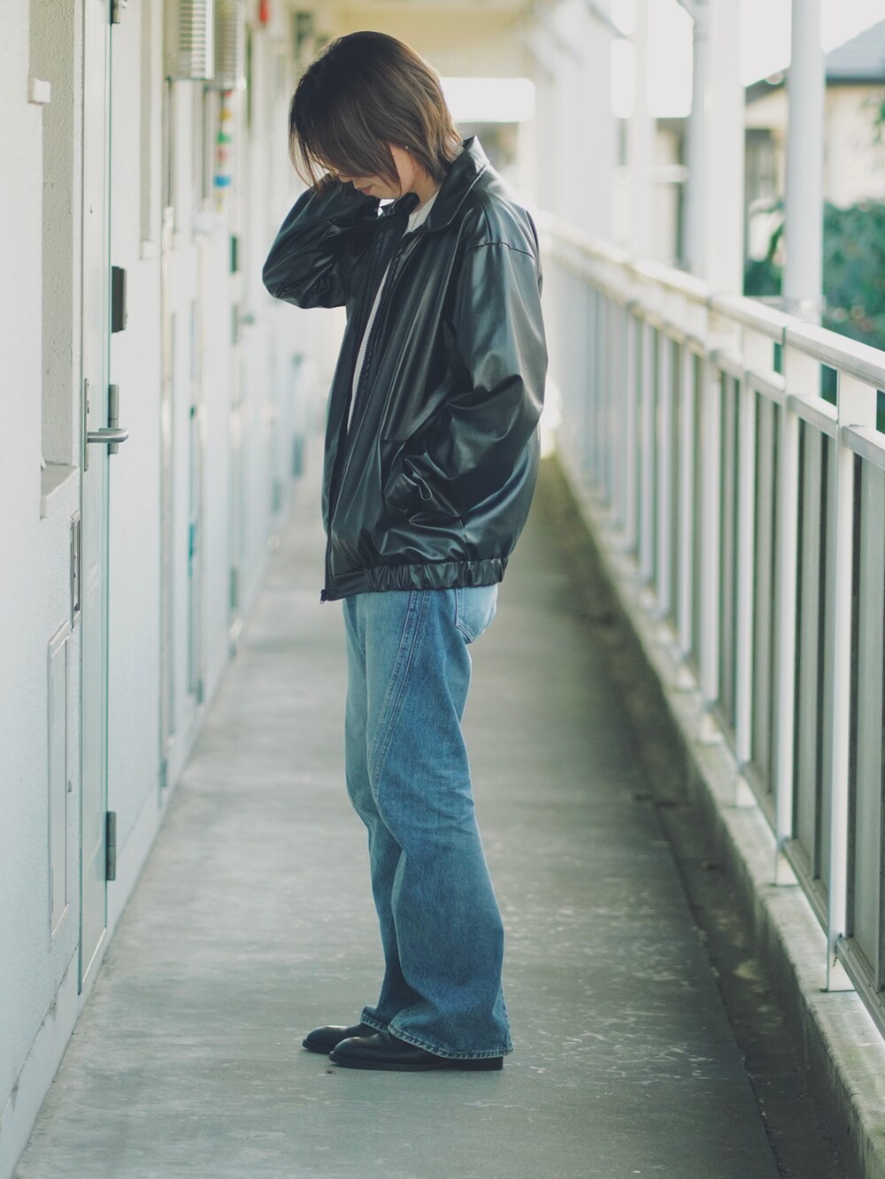 ブルー系のデニムパンツ、ブラック系のサンダル、ホワイト系のTシャツ/カットソーを着用したメンズの春コーディネートの3枚目の写真