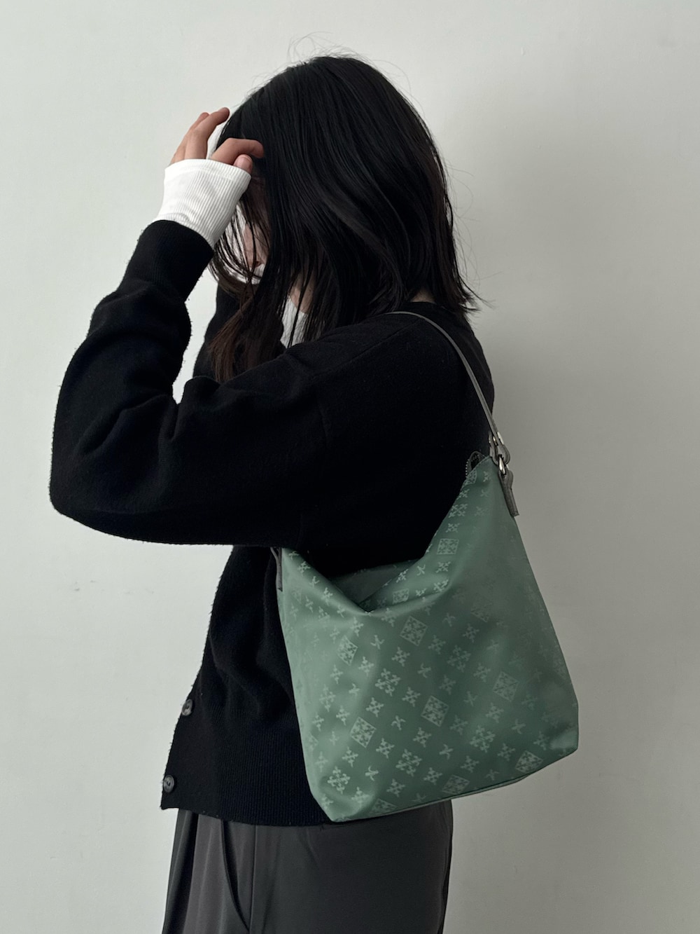 グリーン系のショルダーバッグを着用したレディースの春コーディネートの3枚目の写真