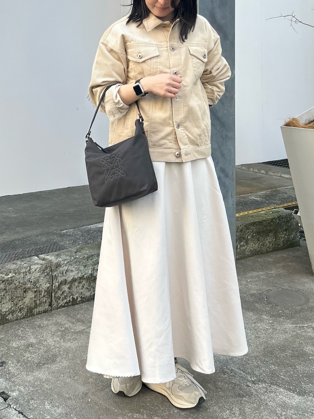 ブラウン系のショルダーバッグを着用したレディースの春コーディネートの3枚目の写真