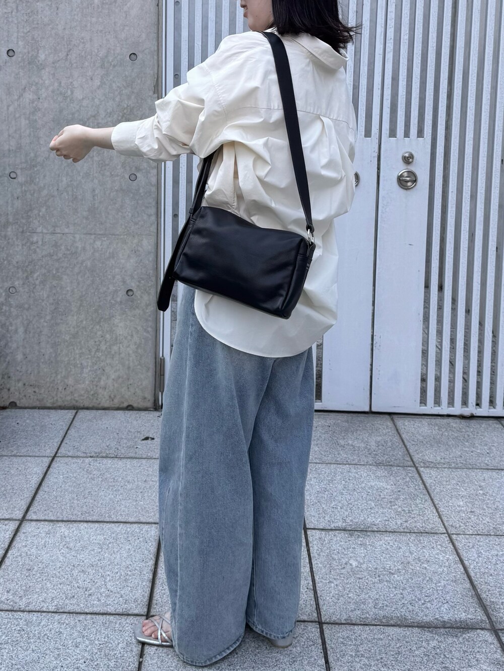 ブラック系のショルダーバッグ、ホワイト系のシャツ/ブラウスを着用したレディースの夏コーディネートの2枚目の写真