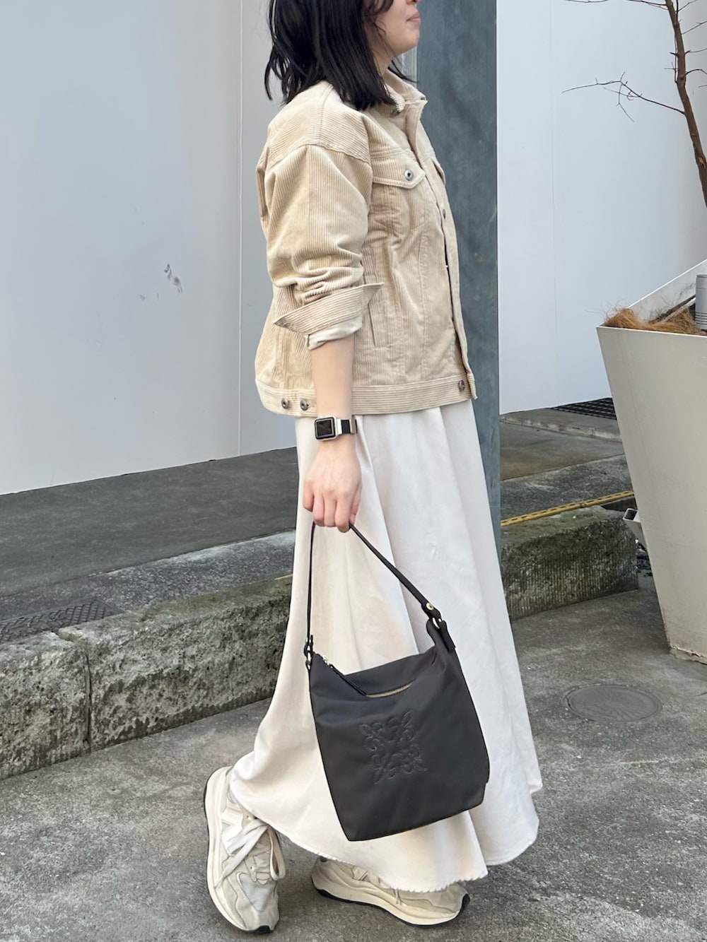 ブラウン系のショルダーバッグを着用したレディースの春コーディネートの2枚目の写真