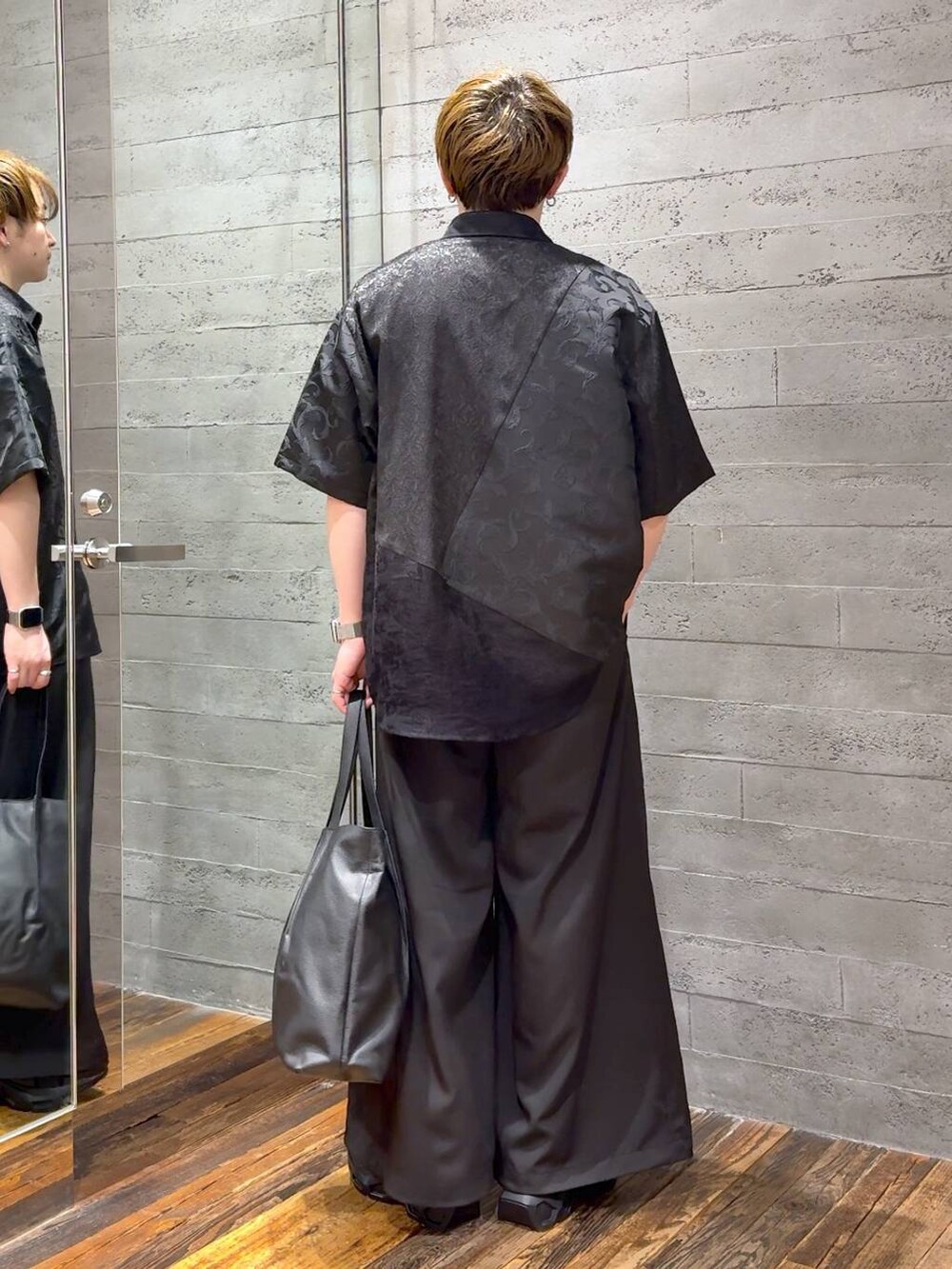 ブラック系のサンダル、ブラック系のTシャツ/カットソー、ブラック系のトートバッグを着用したメンズの春コーディネートの3枚目の写真