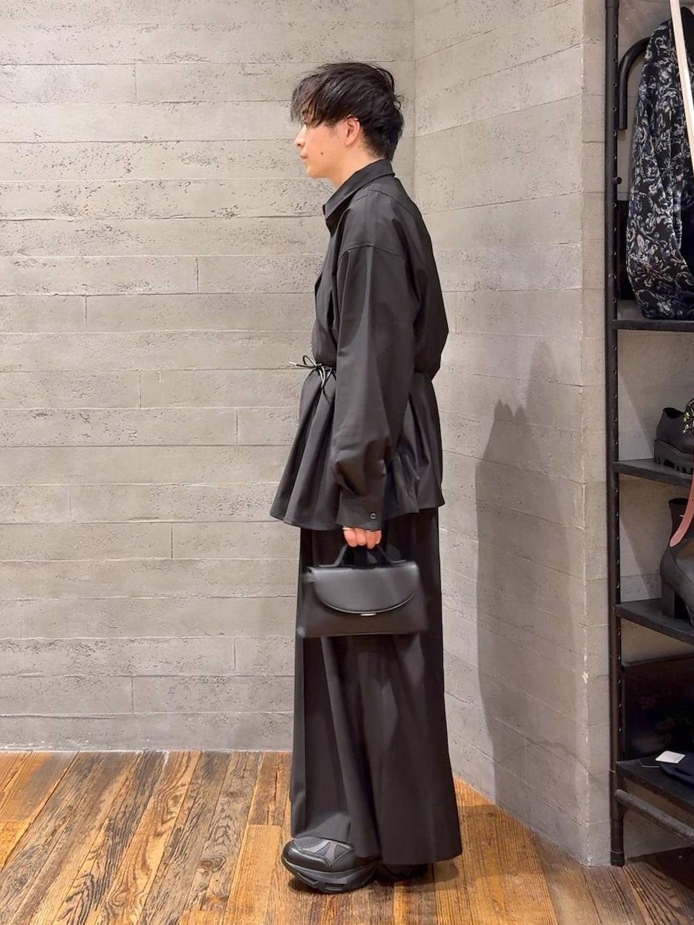 ブラック系のスニーカー、ブラック系のスラックス、ブラック系のショルダーバッグを着用したメンズの冬コーディネートの4枚目の写真