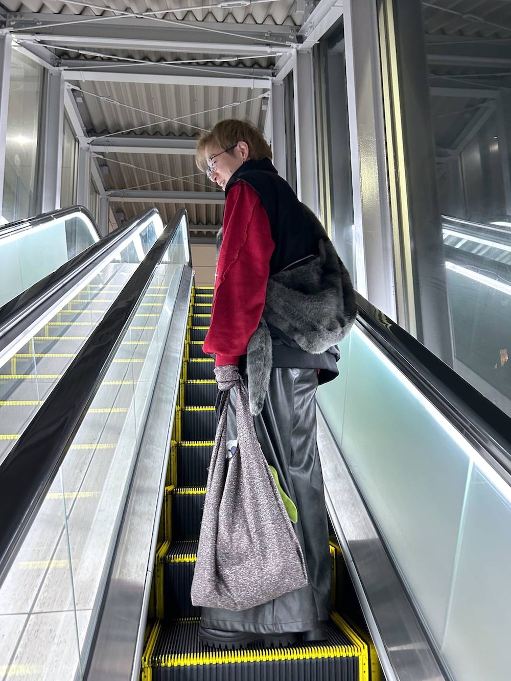 ブラック系のパーカー、グリーン系のニット/セーター、ブラック系のその他パンツを着用したメンズの冬コーディネートの5枚目の写真