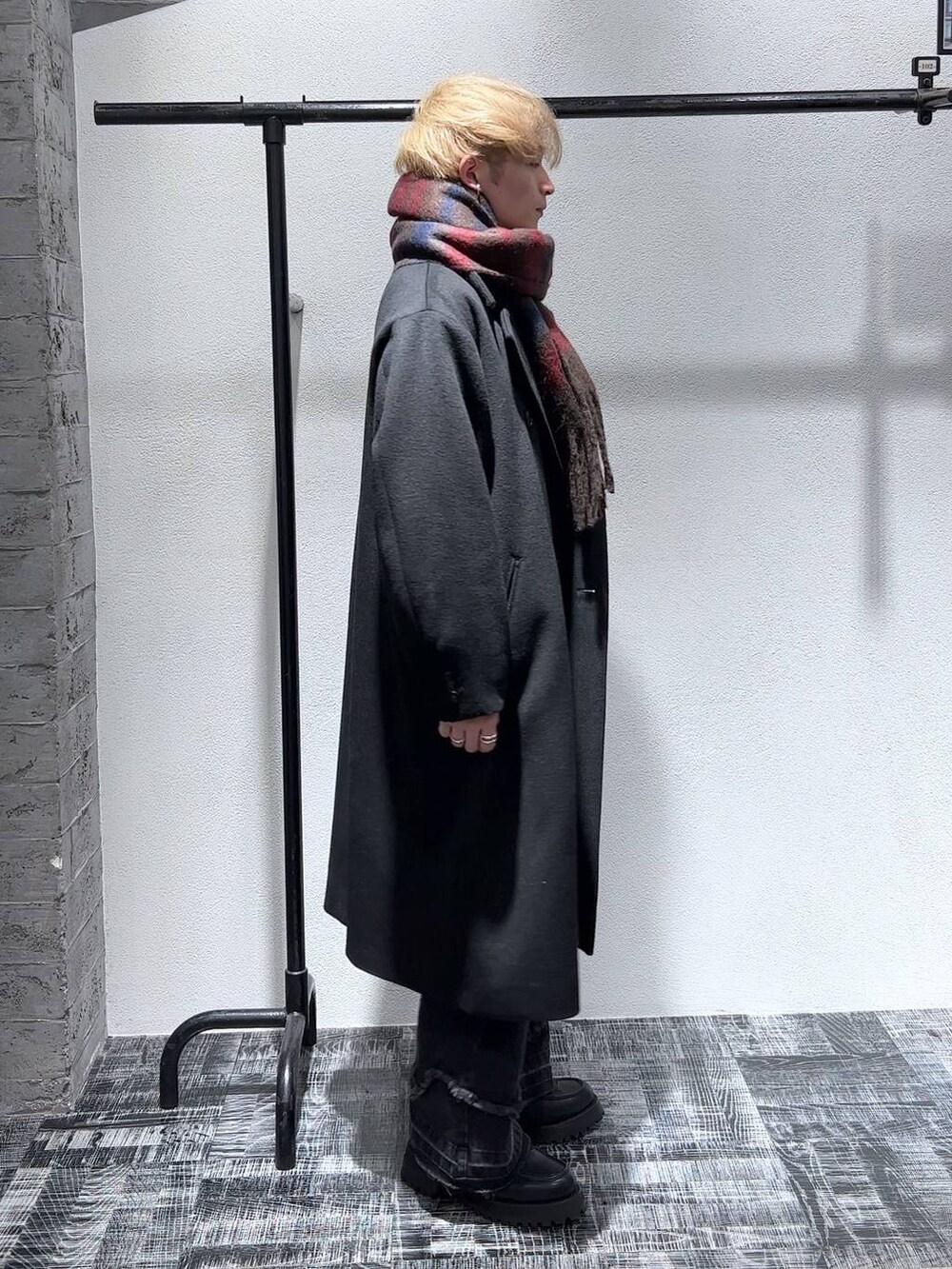 ブラック系のステンカラーコート、ブラック系のローファー、ブラック系のデニムパンツを着用したメンズの秋コーディネートの4枚目の写真