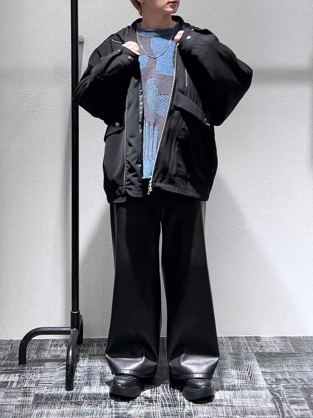 ブルー系のニット/セーター、ブラック系のその他パンツ、ブラック系のスニーカーを着用したメンズの冬コーディネートの2枚目の写真