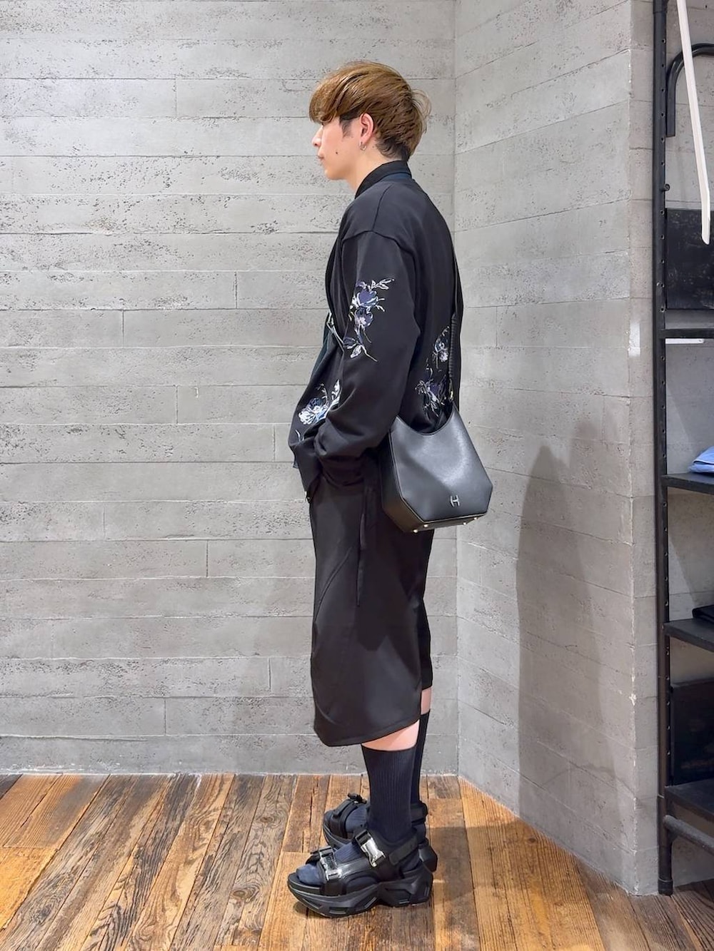 ブラック系のサンダル、ブラック系のスラックス、ブラック系のショルダーバッグを着用したメンズの春コーディネートの4枚目の写真