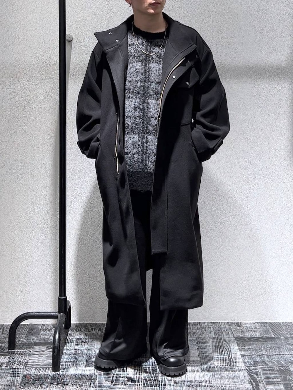 ブラック系のステンカラーコート、ブラック系のブーツ、ブラック系のその他パンツを着用したメンズの秋コーディネートの3枚目の写真