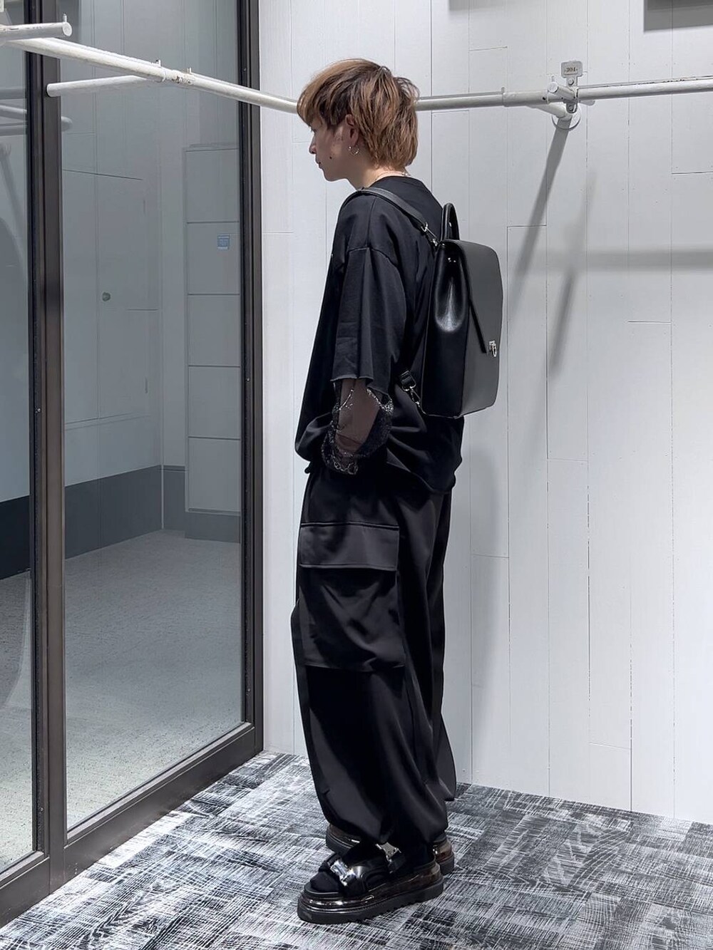 ブラック系のTシャツ/カットソー、ブラック系のサンダル、ブラック系のカーゴパンツを着用したメンズの春コーディネートの2枚目の写真