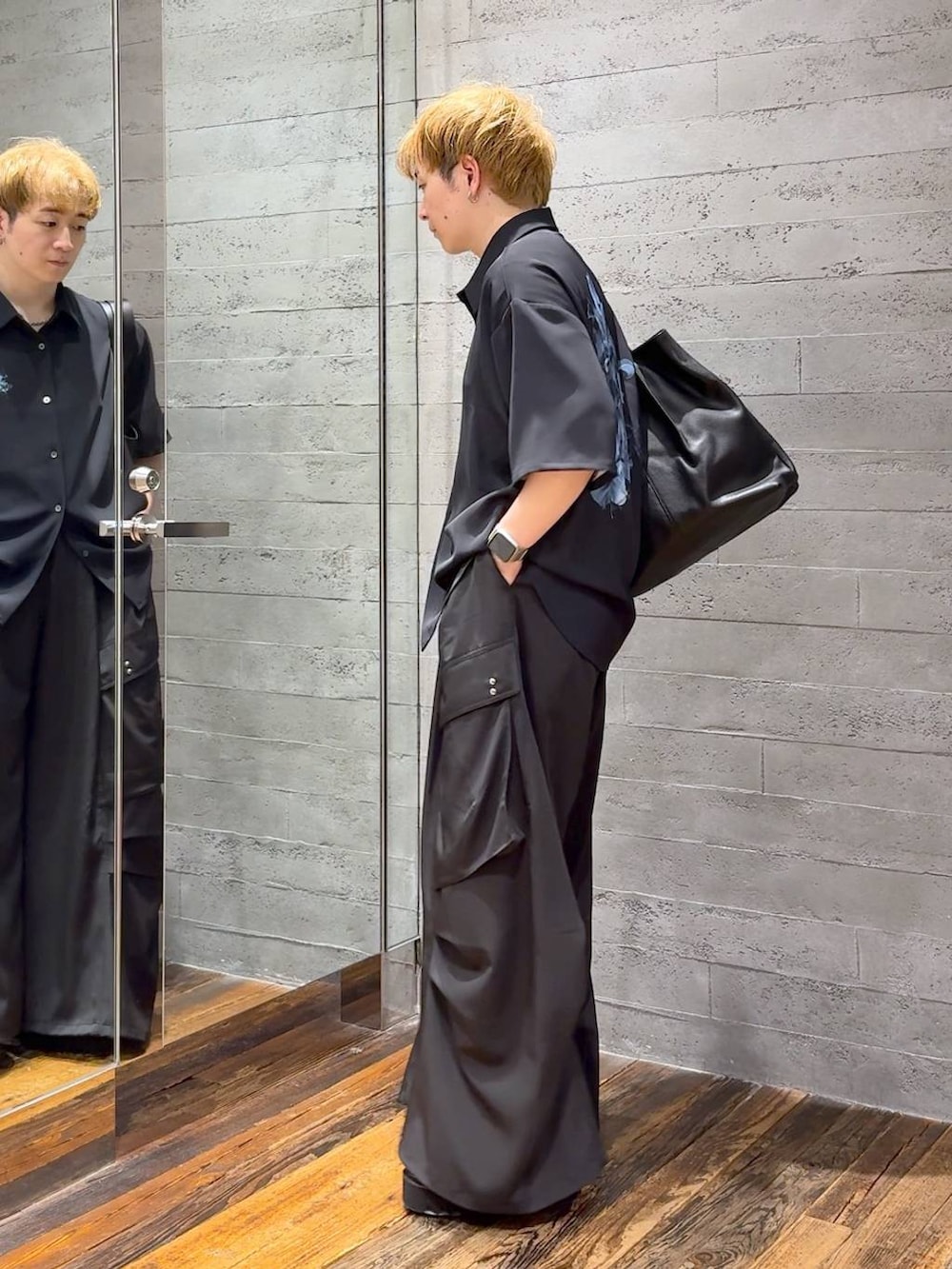 ブラック系のカーゴパンツ、ブラック系のトートバッグ、ブラック系のサンダルを着用したメンズの春コーディネートの4枚目の写真