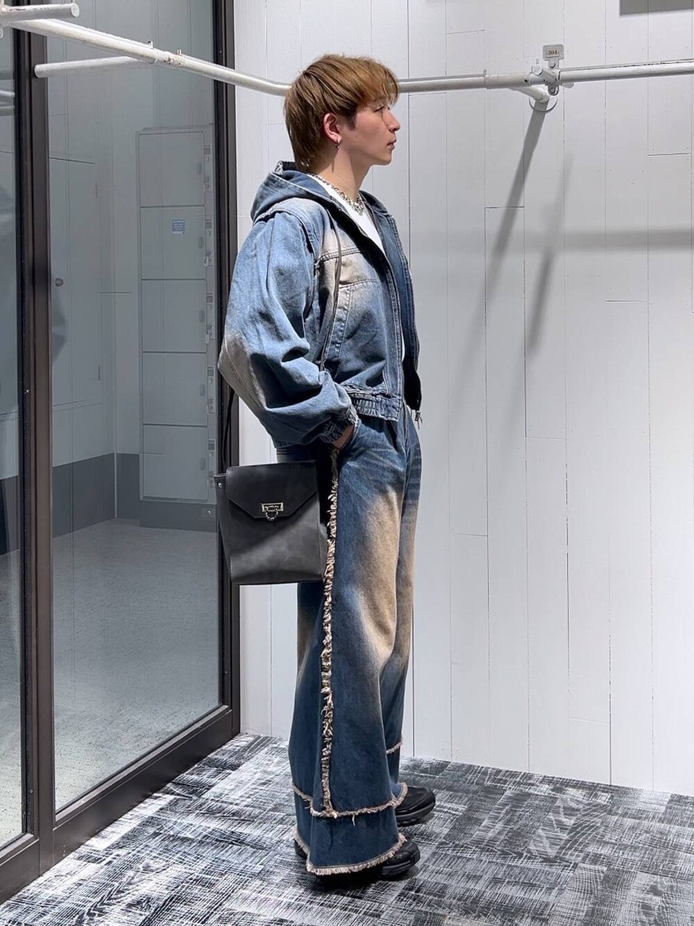 ブルー系のデニムパンツ、グレー系のショルダーバッグ、ホワイト系のTシャツ/カットソーを着用したメンズの冬コーディネートの2枚目の写真