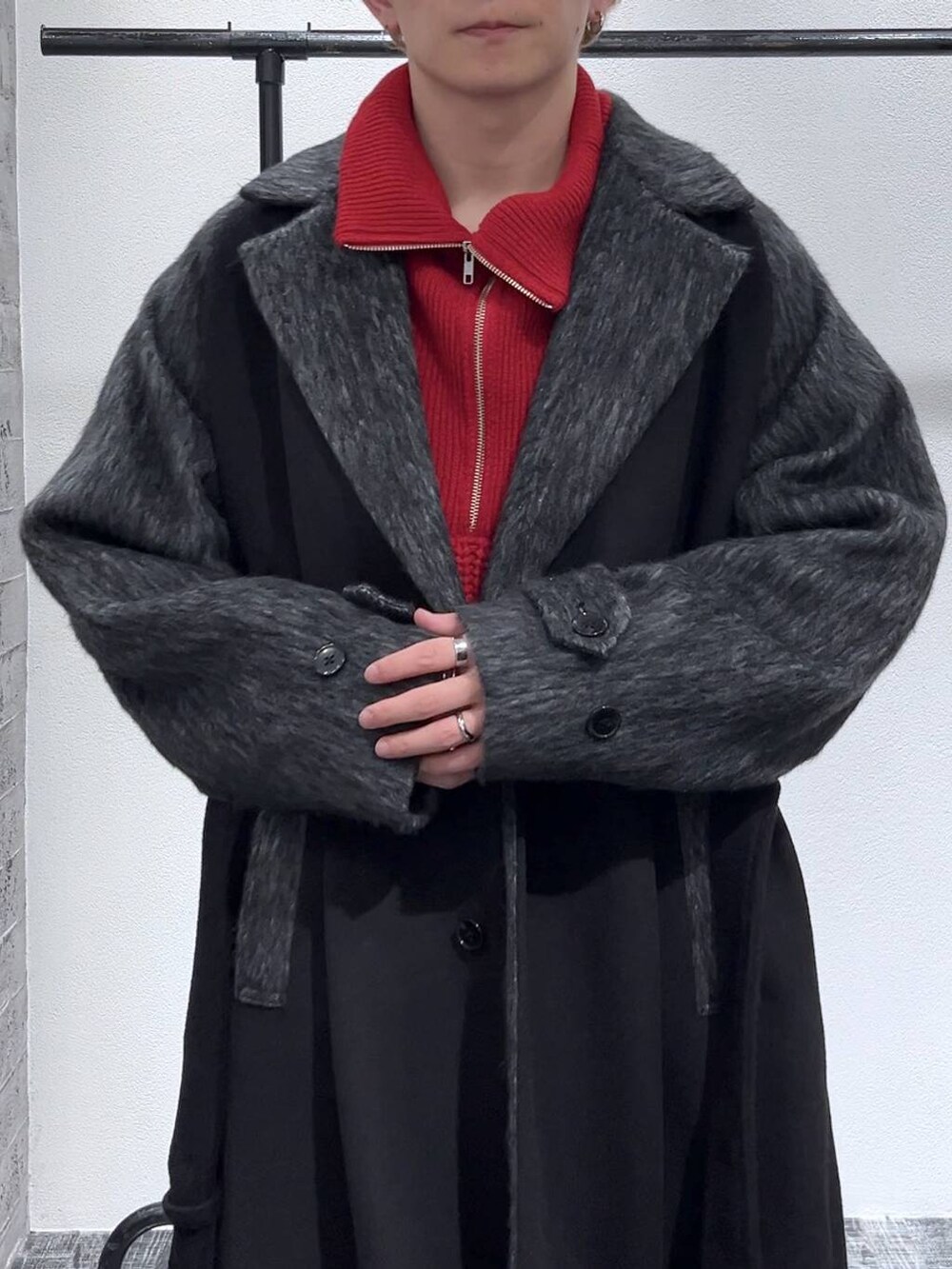 ブラック系のブーツ、ブラック系のダッフルコート、レッド系のニット/セーターを着用したメンズの秋コーディネートの5枚目の写真