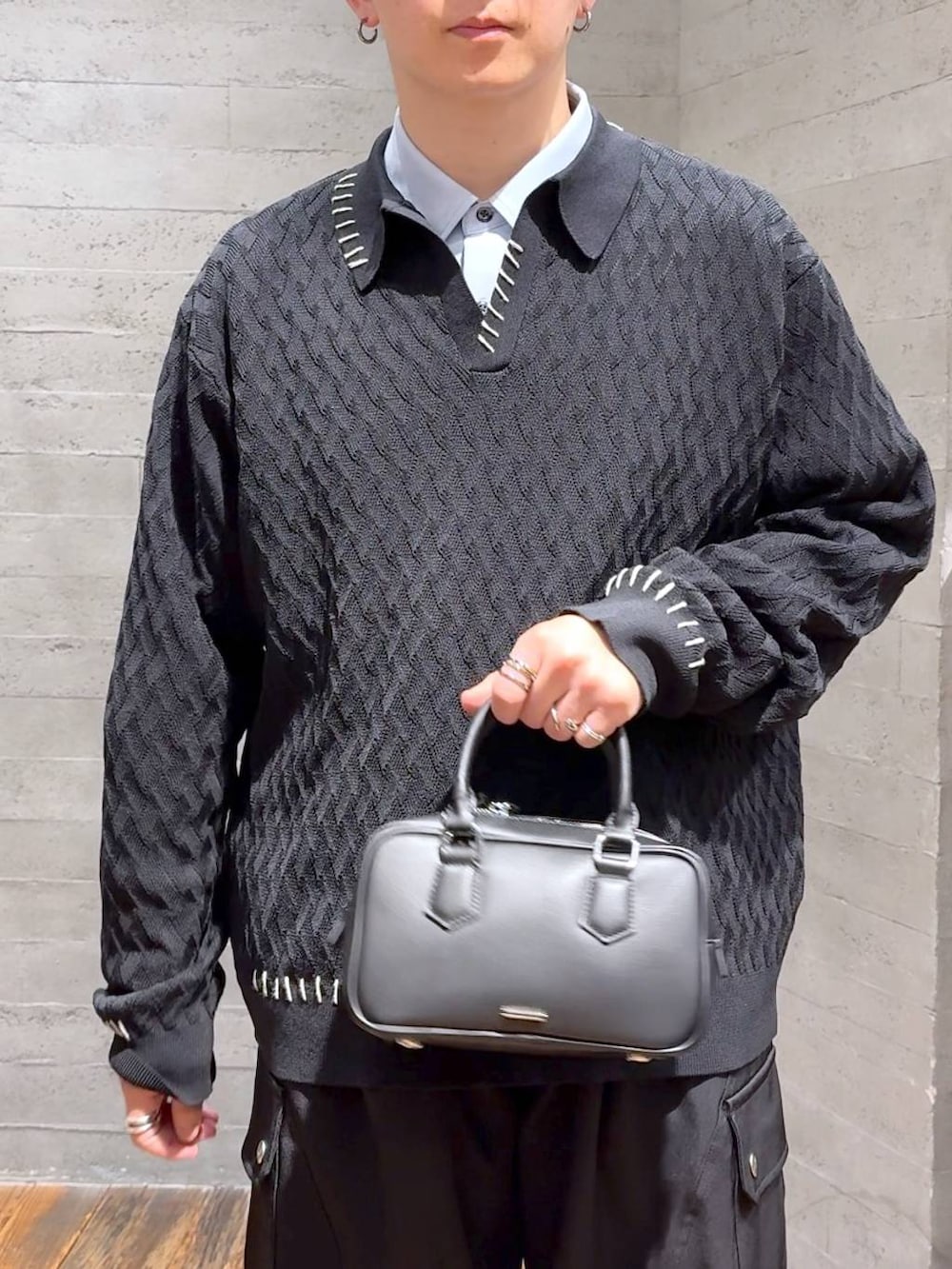 ブラック系のドレスシューズ、ブラック系のボストンバッグ、ブラック系のカーゴパンツを着用したメンズの秋コーディネートの5枚目の写真