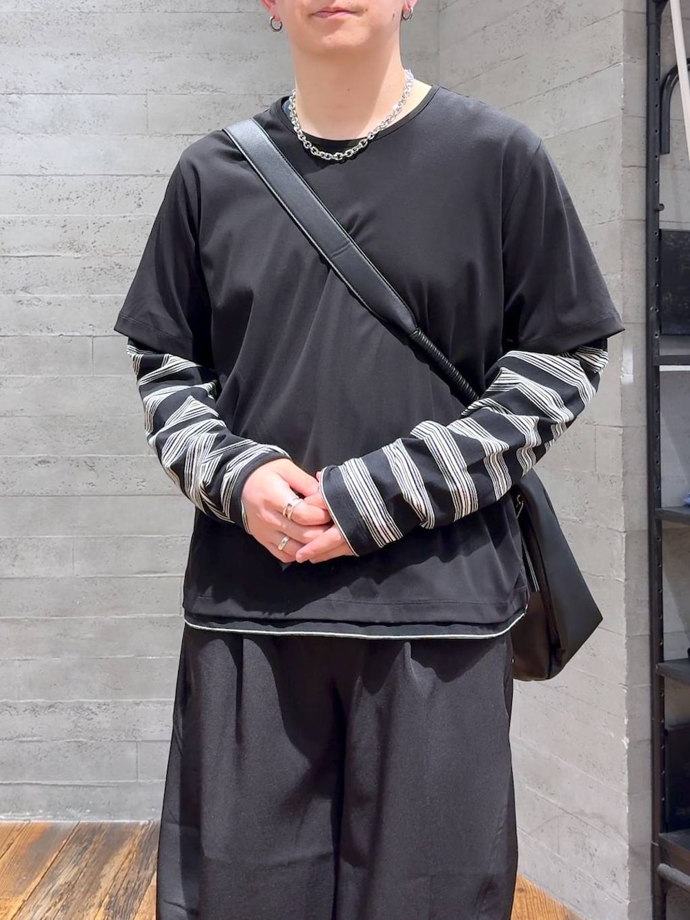 ブラック系のサンダル、ブラック系のショルダーバッグ、ブラック系のスラックスを着用したメンズの春コーディネートの5枚目の写真