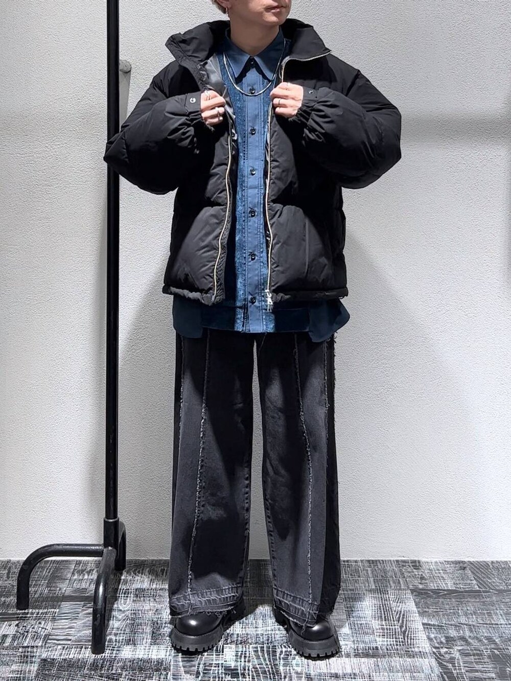 ブラック系のデニムパンツ、ブラック系のダウンジャケット/コート、ブラック系のブーツを着用したメンズの秋コーディネートの2枚目の写真