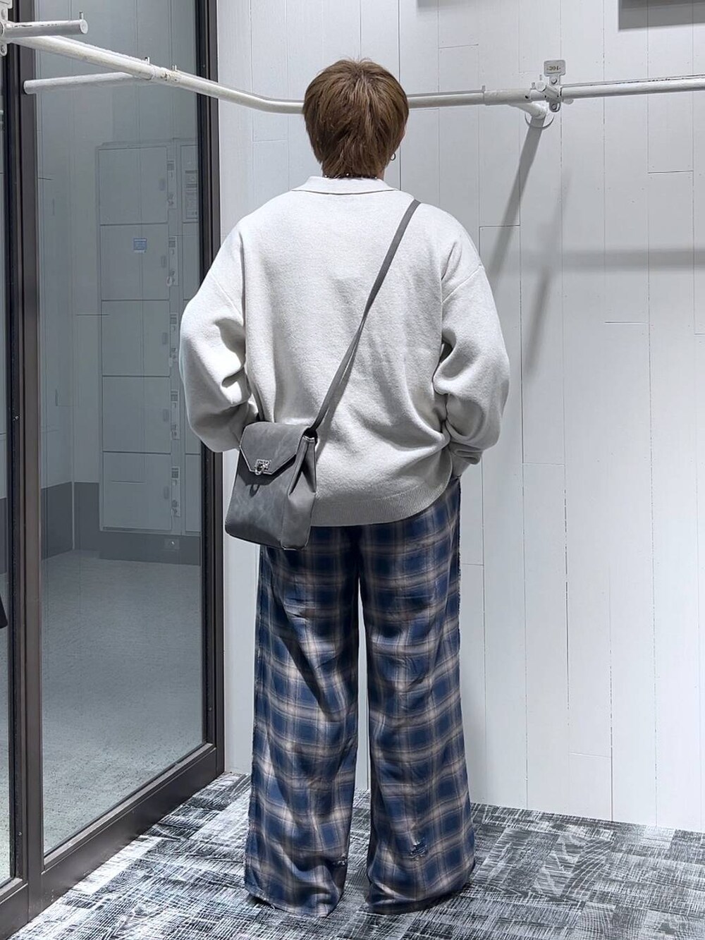 ブルー系のその他パンツ、ブラック系のドレスシューズ、グレー系のショルダーバッグを着用したメンズの冬コーディネートの3枚目の写真