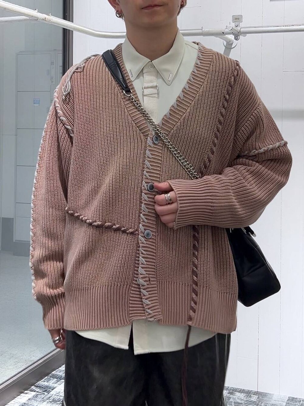 グレー系のカーゴパンツ、ブラック系のショルダーバッグ、ピンク系のカーディガン/ボレロを着用したメンズの冬コーディネートの5枚目の写真