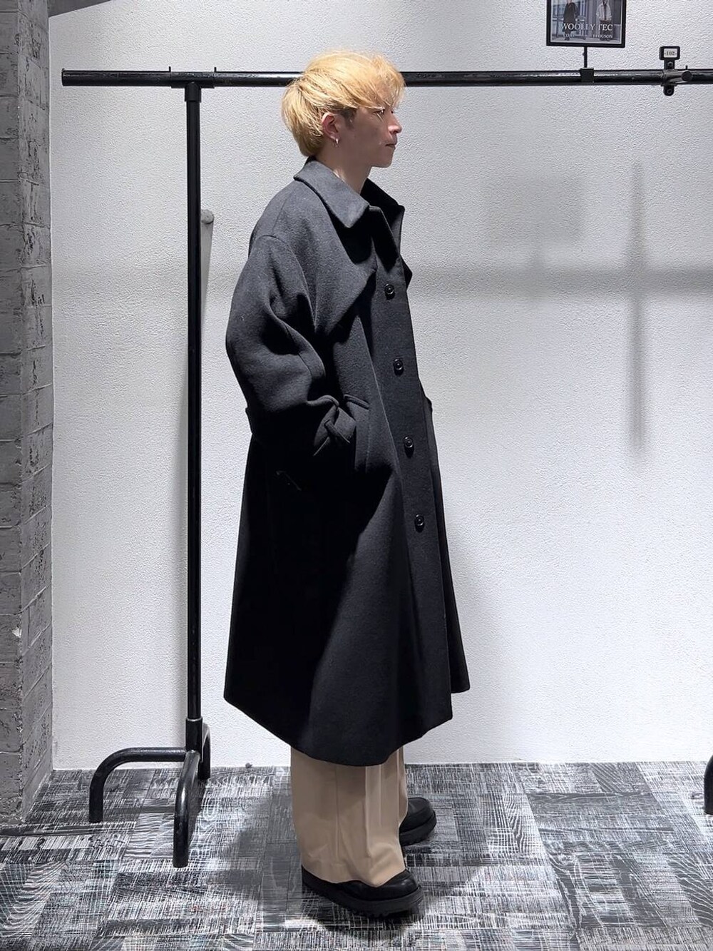 ブラック系のステンカラーコート、ブラック系のドレスシューズ、グレー系のスウェットを着用したメンズの冬コーディネートの3枚目の写真