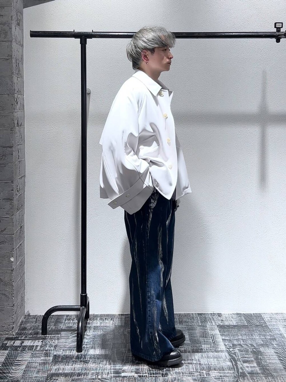 ブラック系のドレスシューズ、ホワイト系のブルゾン、ブルー系のデニムパンツを着用したメンズの冬コーディネートの3枚目の写真