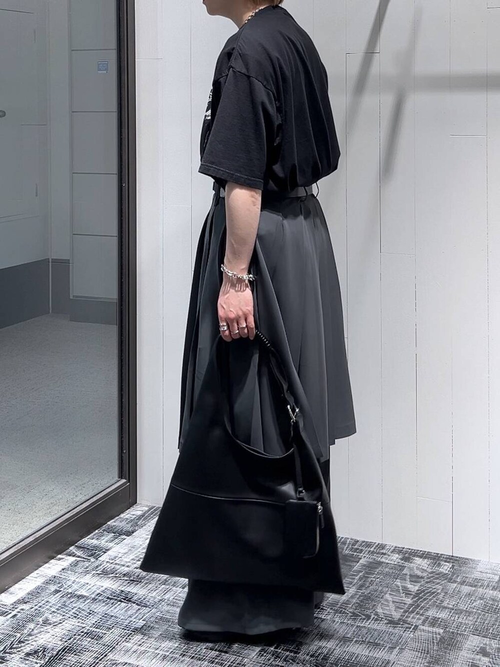 ブラック系のサンダル、ブラック系のTシャツ/カットソー、ブラック系のトートバッグを着用したメンズの春コーディネートの4枚目の写真
