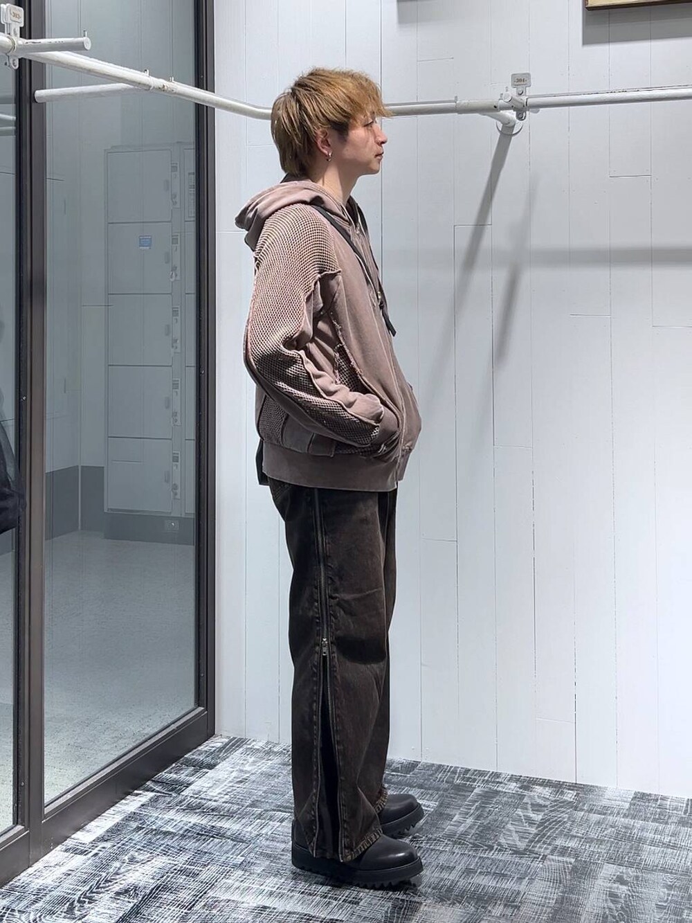 オレンジ系のデニムパンツ、ブラウン系のパーカー、ブラック系のドレスシューズを着用したメンズの春コーディネートの2枚目の写真