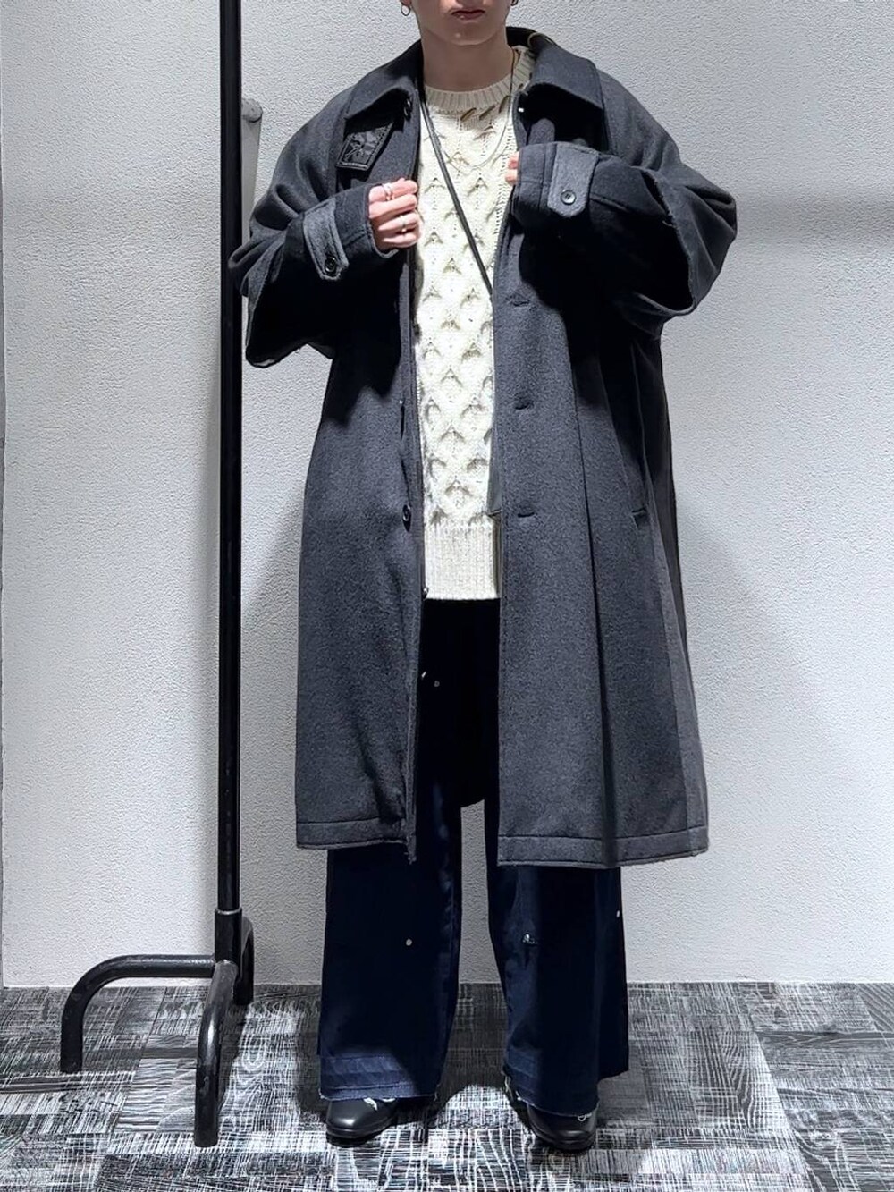 ブラック系のドレスシューズ、ブルー系のデニムパンツ、グレー系のトレンチコートを着用したメンズの秋コーディネートの2枚目の写真