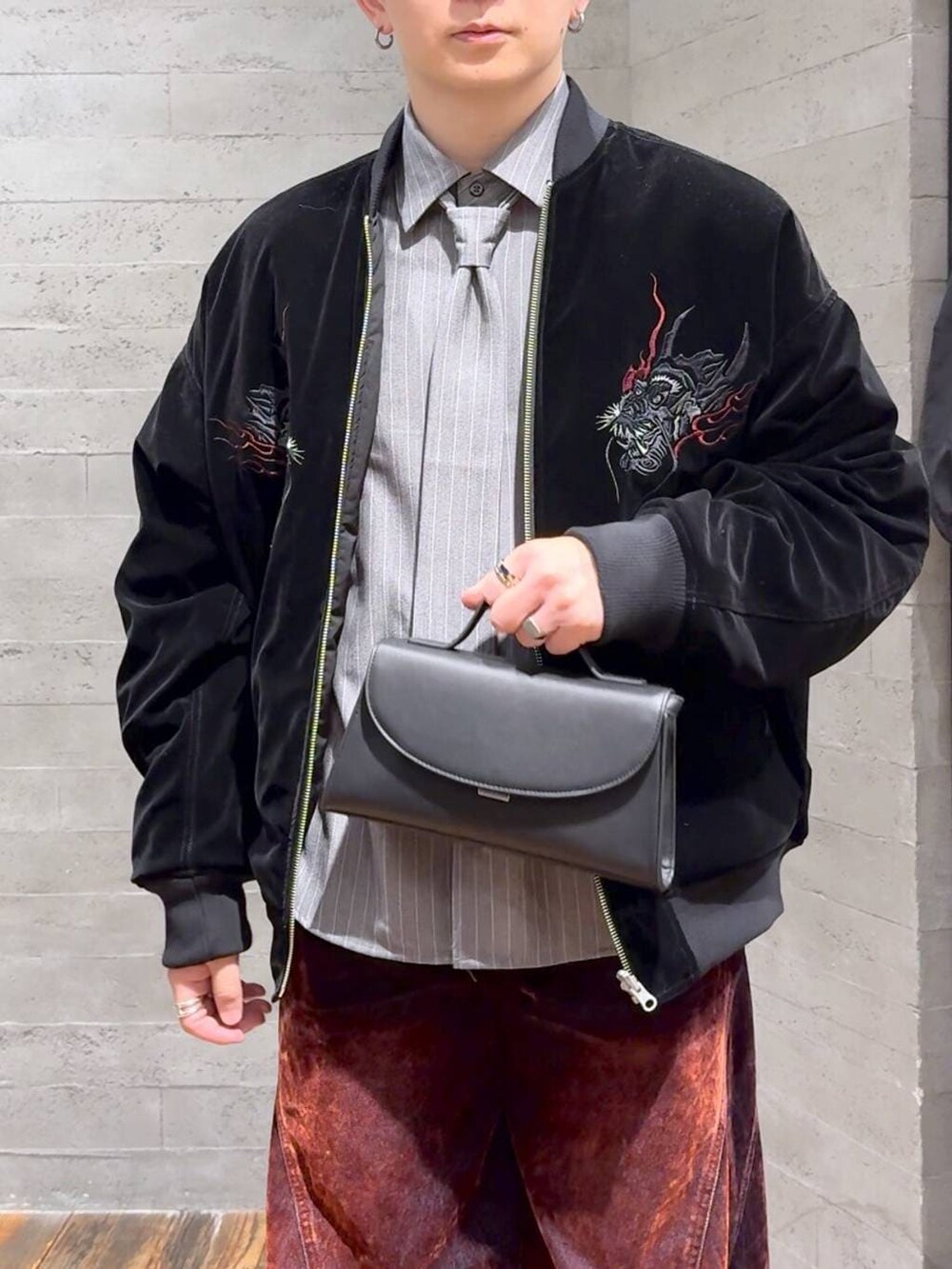 ブラック系のブーツ、レッド系のデニムパンツ、ブラック系のショルダーバッグを着用したメンズの冬コーディネートの5枚目の写真
