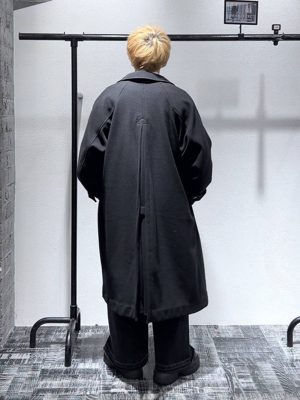 ブラック系のステンカラーコート、ブラック系のショルダーバッグ、グレー系のカーディガン/ボレロを着用したメンズの冬コーディネートの4枚目の写真