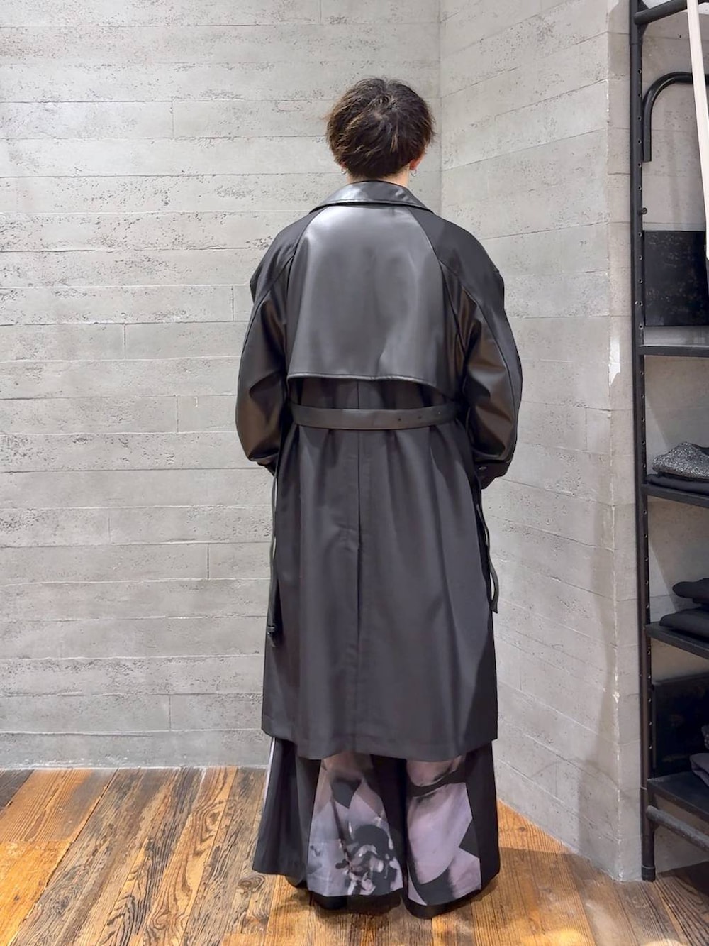 ブラック系のトレンチコート、ブラック系のブーツ、シルバー系のネックレスを着用したメンズの秋コーディネートの3枚目の写真