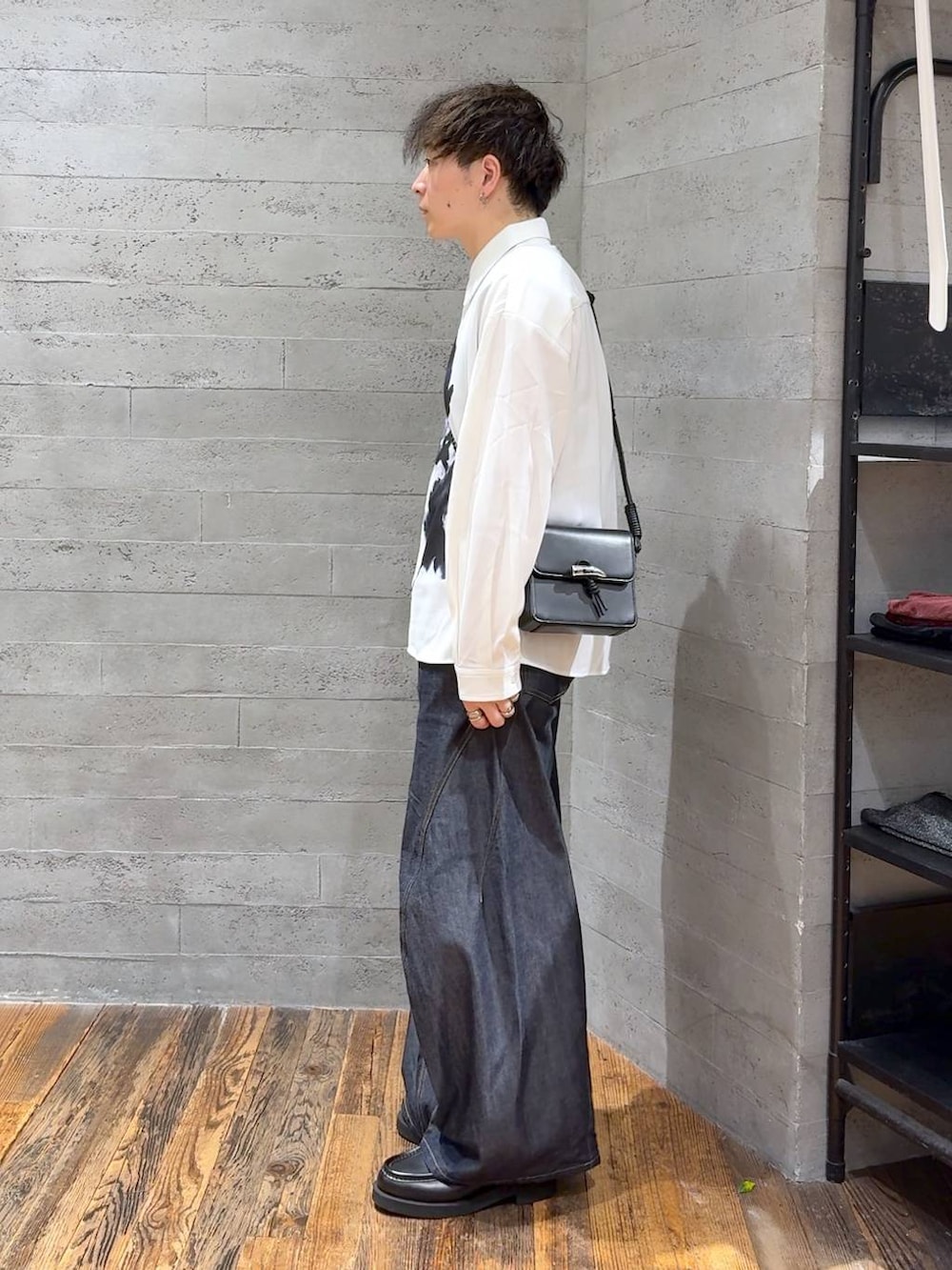 ブルー系のデニムパンツ、ブラック系のローファー、ブラック系のショルダーバッグを着用したメンズの秋コーディネートの4枚目の写真