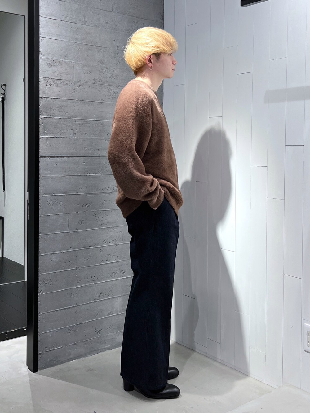 ブラウン系のニット/セーター、ブルー系のデニムパンツ、ブラック系のブーツを着用したメンズの秋コーディネートの3枚目の写真