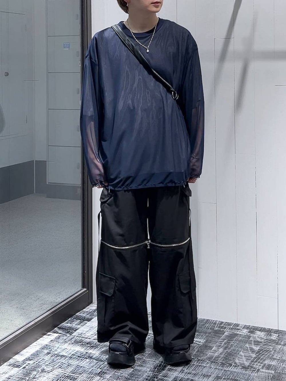 ブラック系のサンダル、グレー系のTシャツ/カットソー、ブラック系のカーゴパンツを着用したメンズの春コーディネートの2枚目の写真