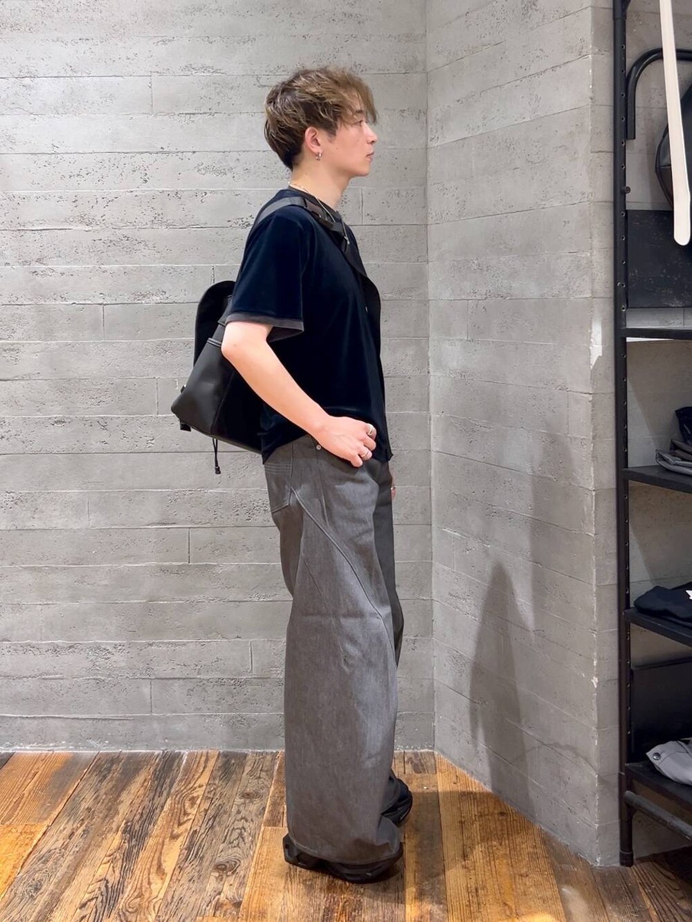 グレー系のデニムパンツ、ブラック系のサンダル、ブラック系のメッセンジャーバッグを着用したメンズの夏コーディネートの2枚目の写真