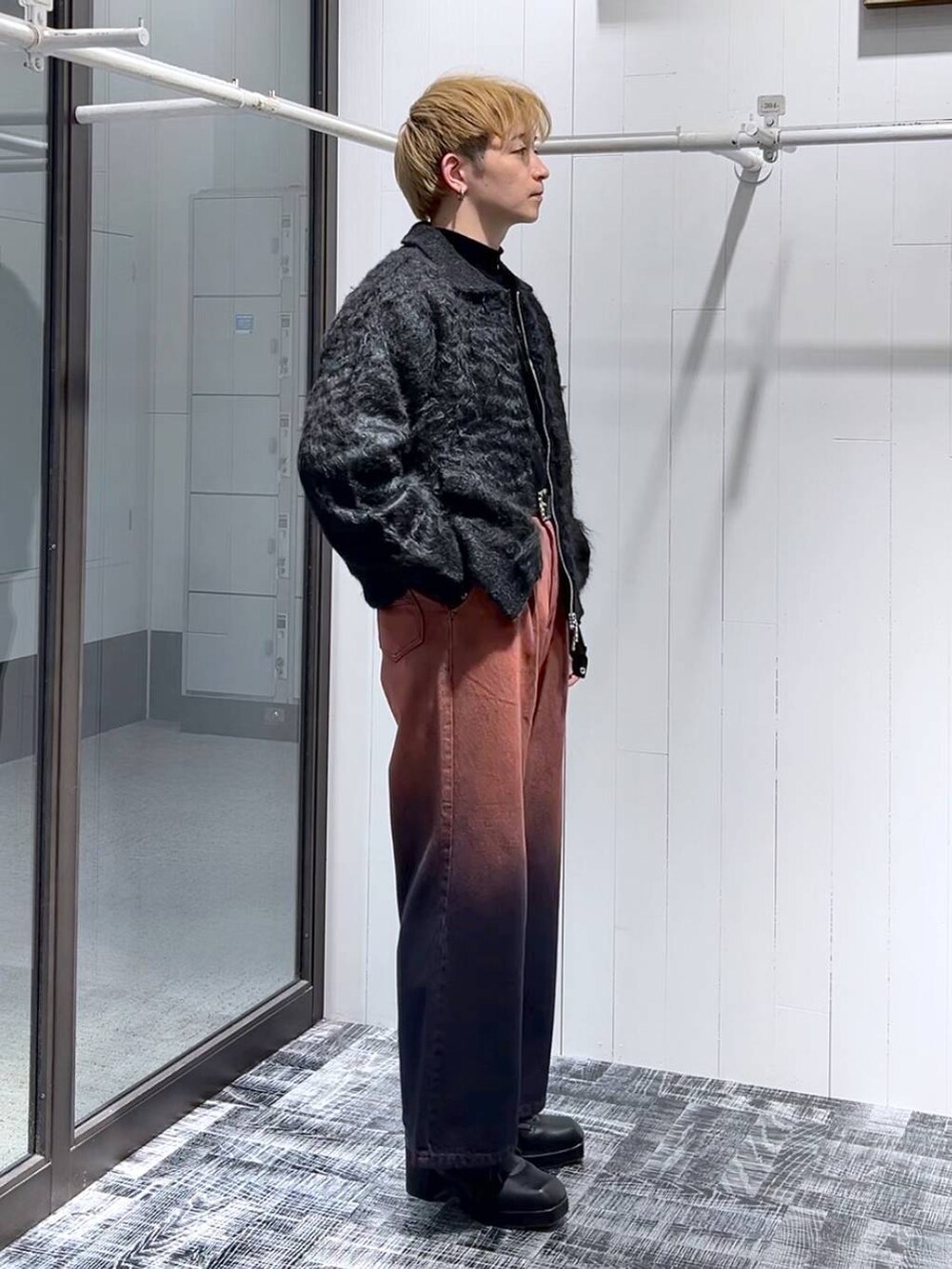 オレンジ系のデニムパンツ、ブラック系のTシャツ/カットソー、ブラック系のブーツを着用したメンズの冬コーディネートの2枚目の写真