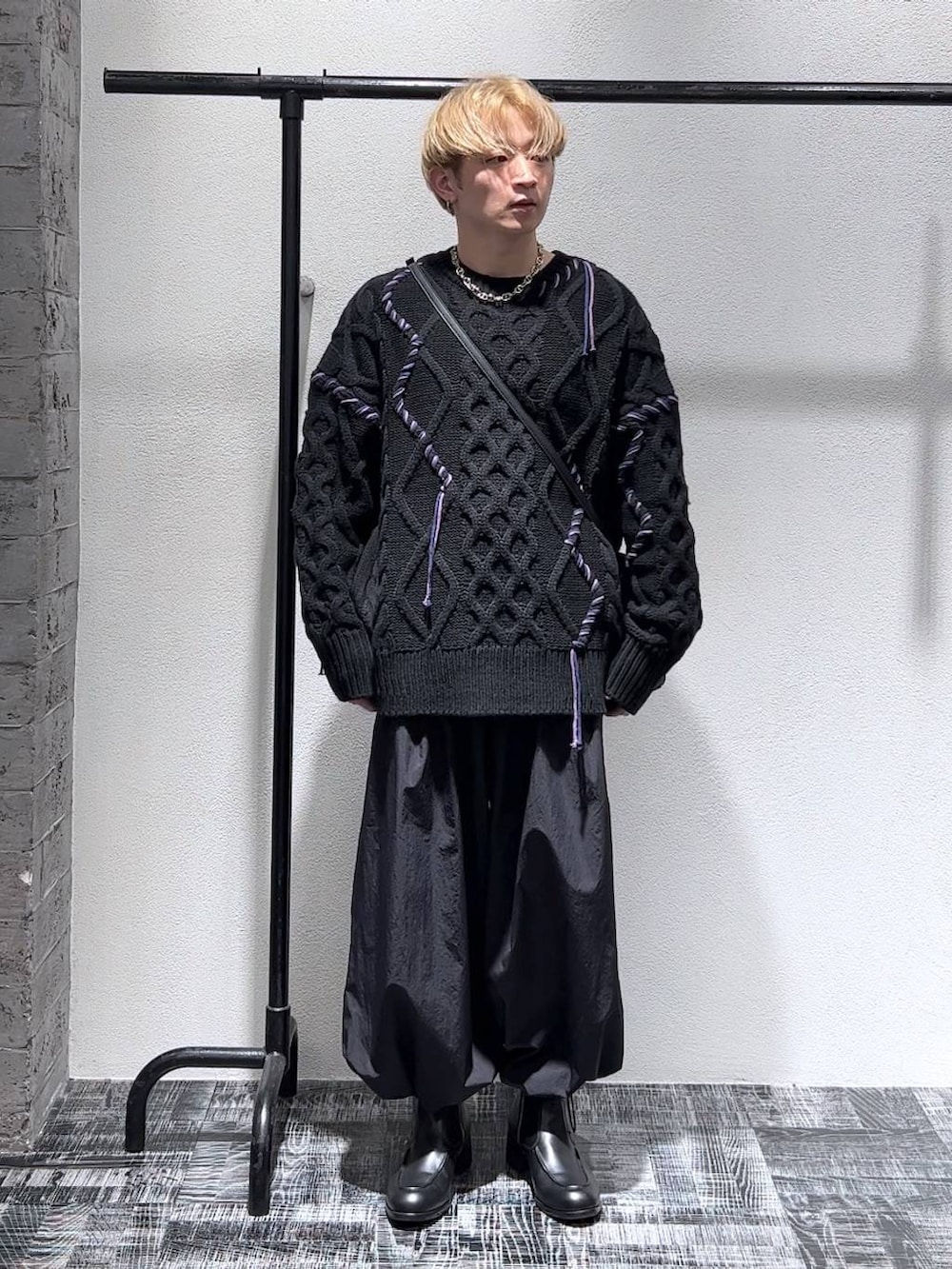 ブラック系のショルダーバッグ、ブラック系のブーツ、ブラック系のニット/セーターを着用したメンズの秋コーディネートの2枚目の写真