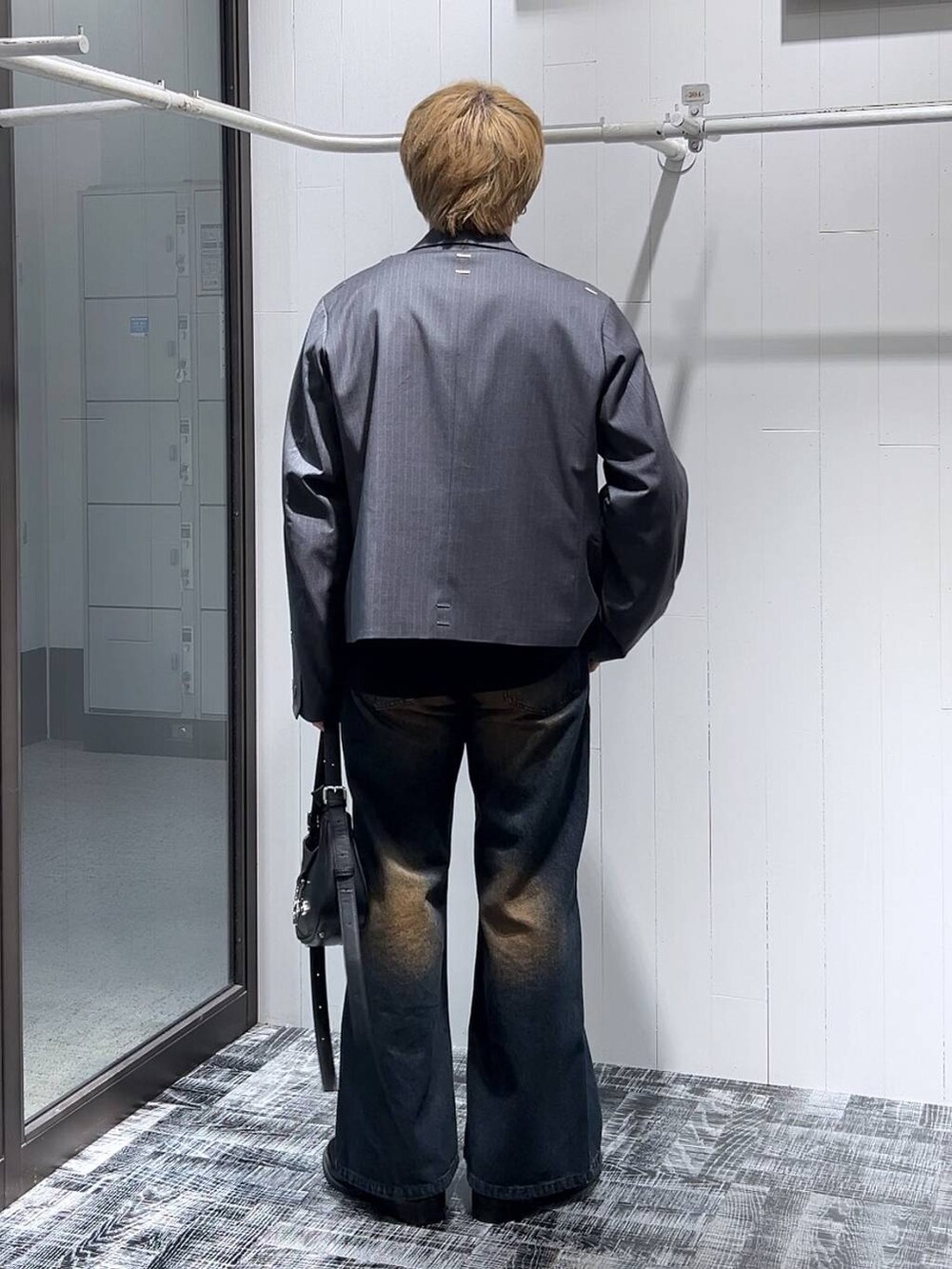 ブルー系のデニムパンツ、ブラック系のTシャツ/カットソー、ブラック系のドレスシューズを着用したメンズの冬コーディネートの3枚目の写真