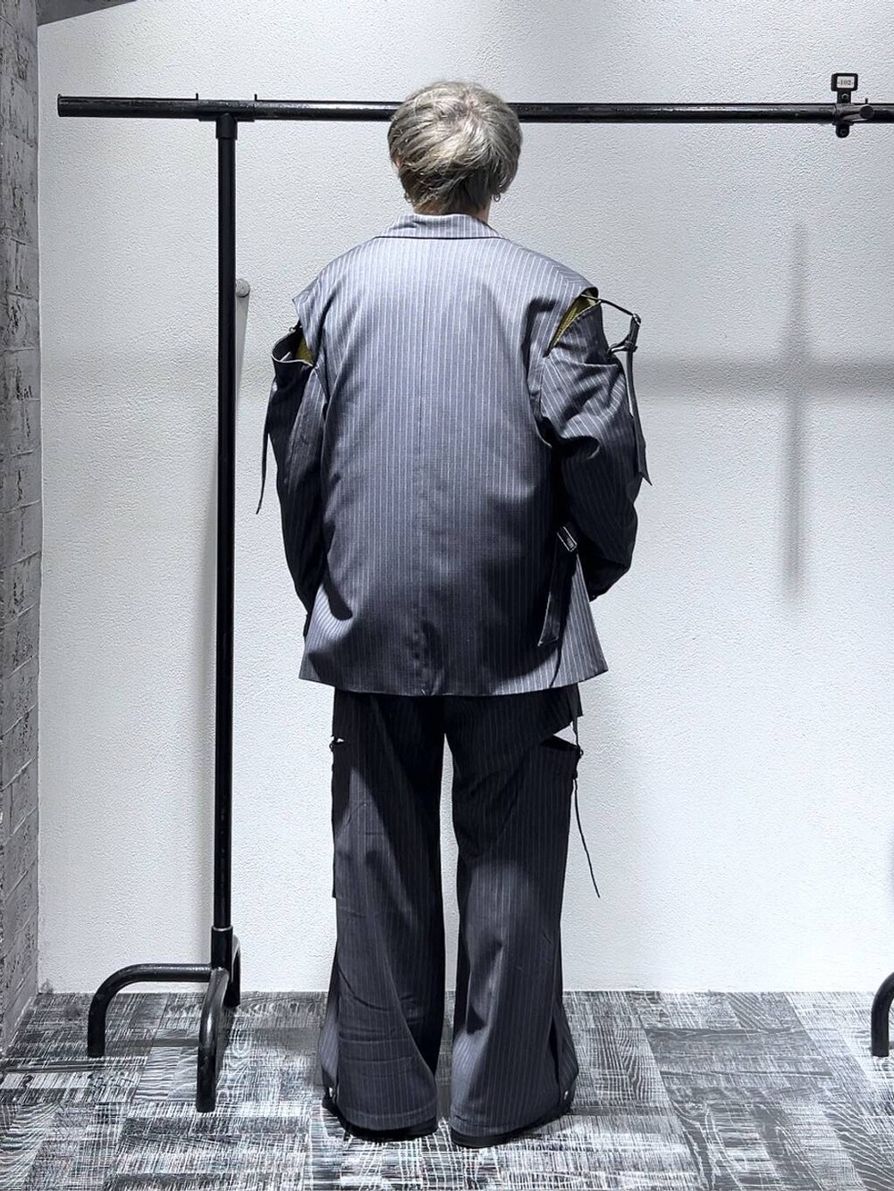 グレー系のテーラードジャケット、グレー系のスラックス、ブラック系のドレスシューズを着用したメンズの冬コーディネートの3枚目の写真