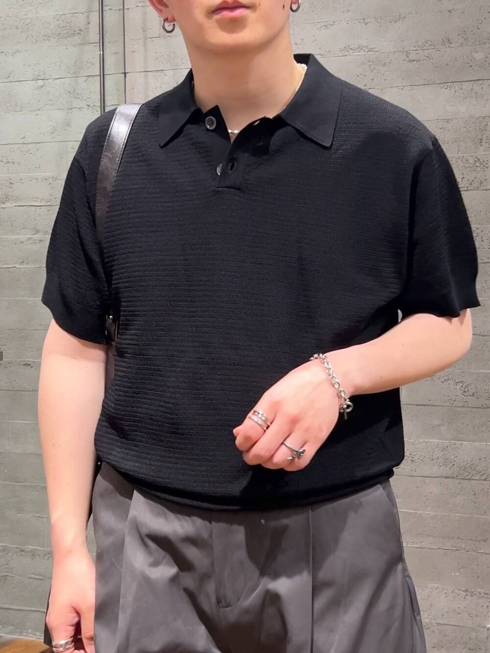 ブラック系のショルダーバッグ、ブラック系のローファー、グレー系のチノパンツを着用したメンズの夏コーディネートの5枚目の写真