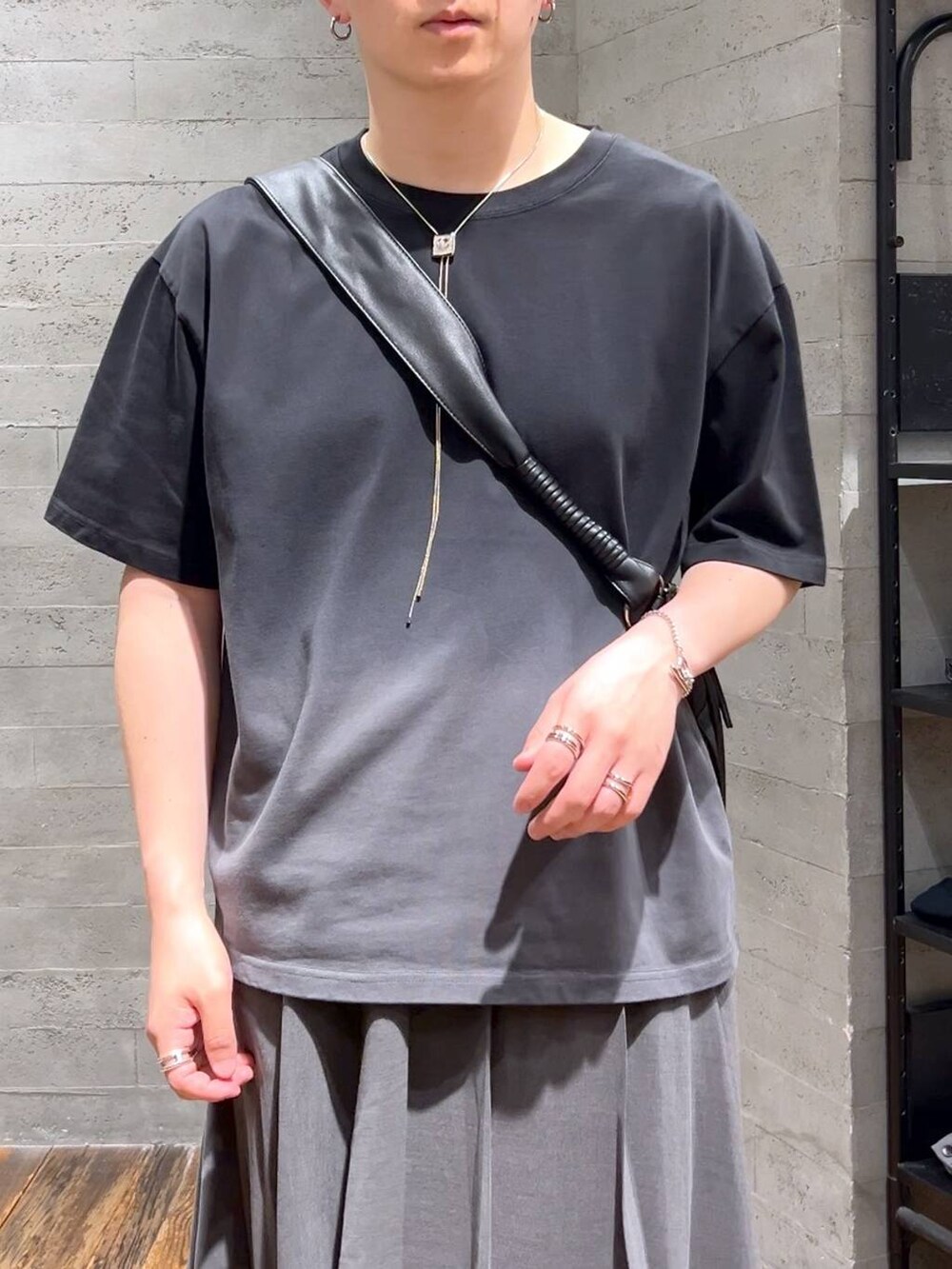 ブラック系のスニーカー、ブラック系のショルダーバッグ、ブラック系のTシャツ/カットソーを着用したメンズの夏コーディネートの5枚目の写真