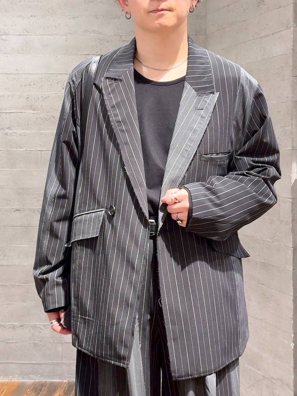 ブラック系のTシャツ/カットソー、ブラック系のブーツ、ブラック系のテーラードジャケットを着用したメンズの秋コーディネートの5枚目の写真