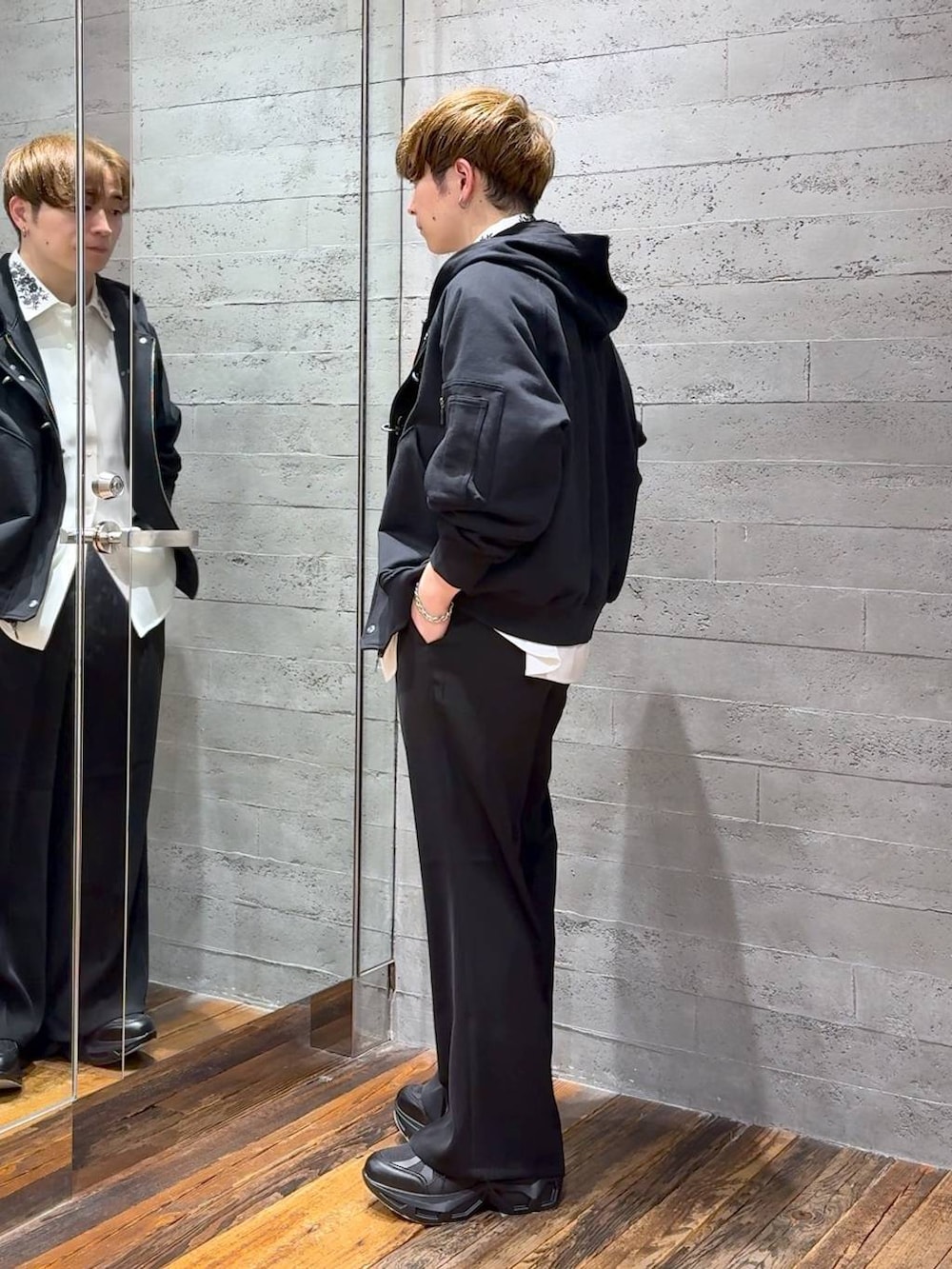 ブラック系のスラックス、ブラック系のスニーカー、ホワイト系のシャツ/ブラウスを着用したメンズの春コーディネートの4枚目の写真