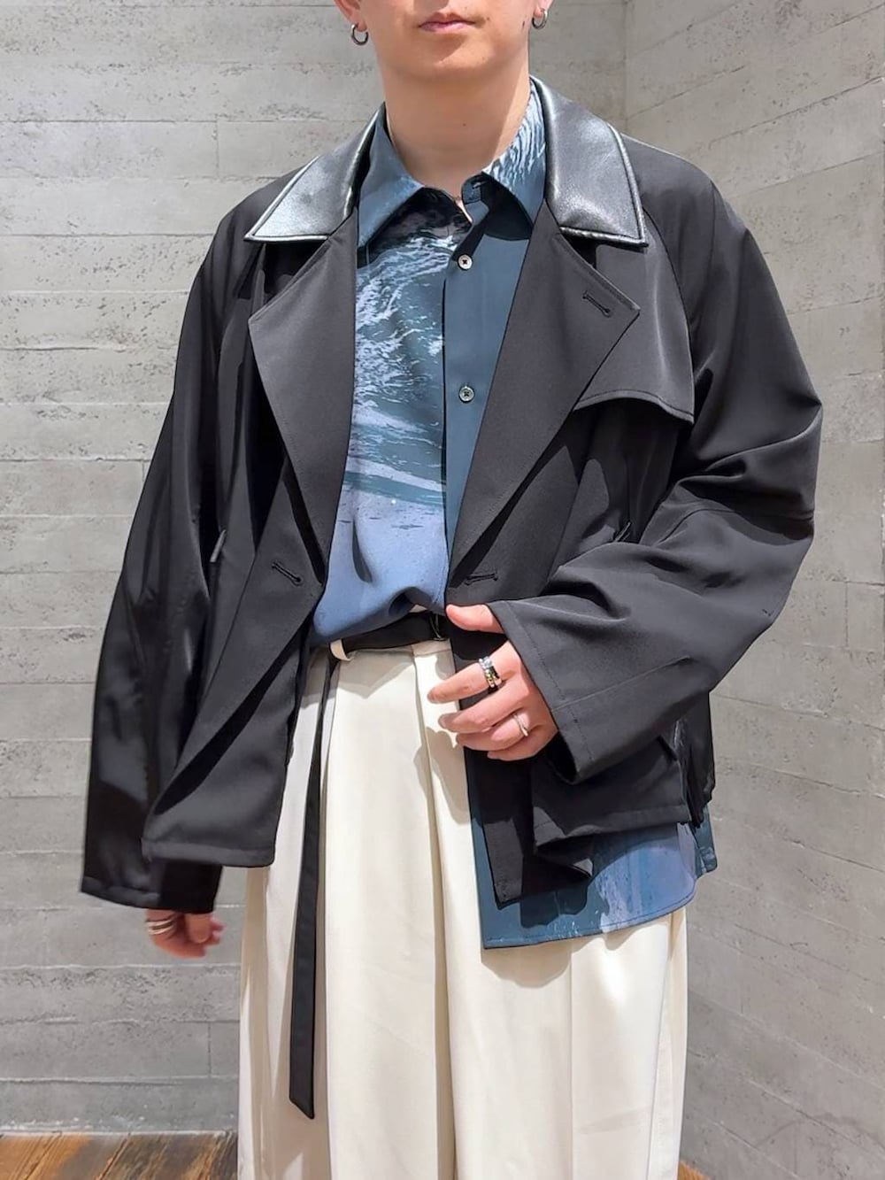 ブラック系のブーツ、ホワイト系のスラックス、ブラック系のブルゾンを着用したメンズの春コーディネートの5枚目の写真