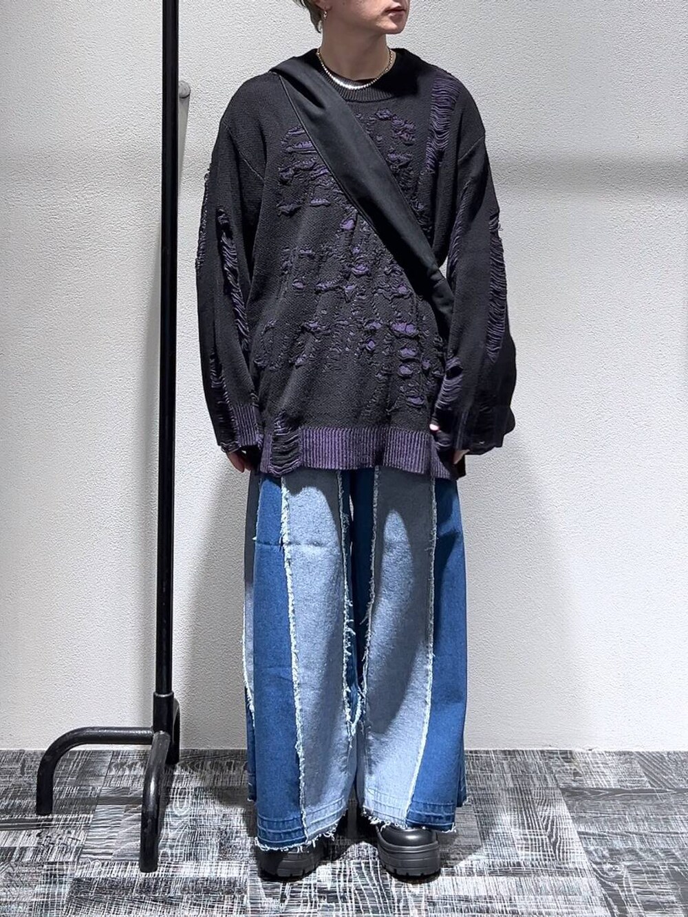 ブラック系のショルダーバッグ、ブラック系のスニーカー、ブルー系のデニムパンツを着用したメンズの冬コーディネートの2枚目の写真