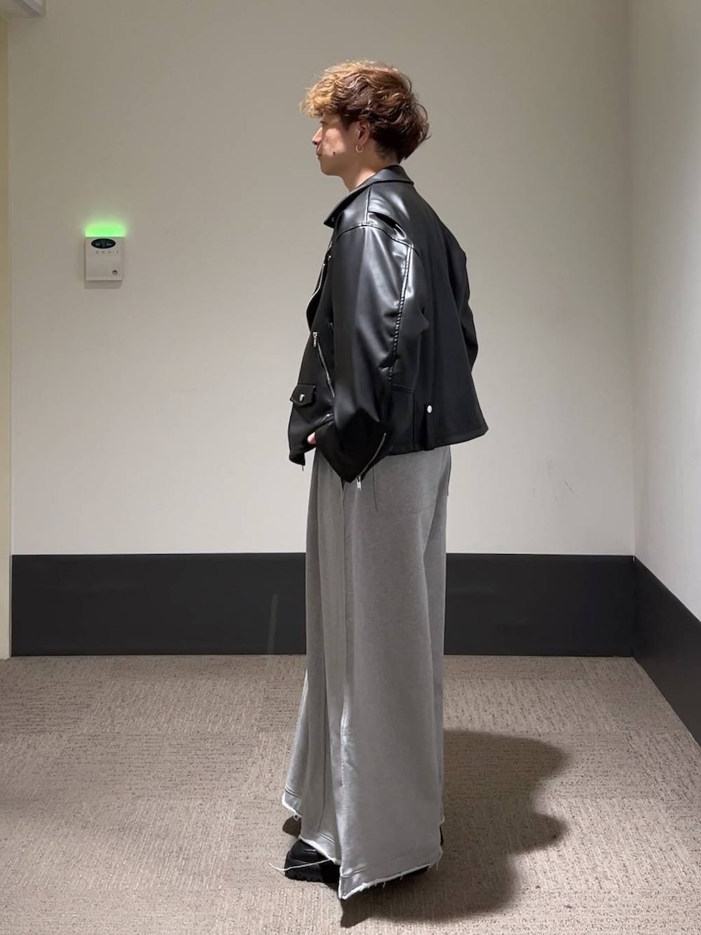 ブラック系のドレスシューズ、グレー系のスウェットパンツ、ブラック系のライダースジャケットを着用したメンズの秋コーディネートの4枚目の写真